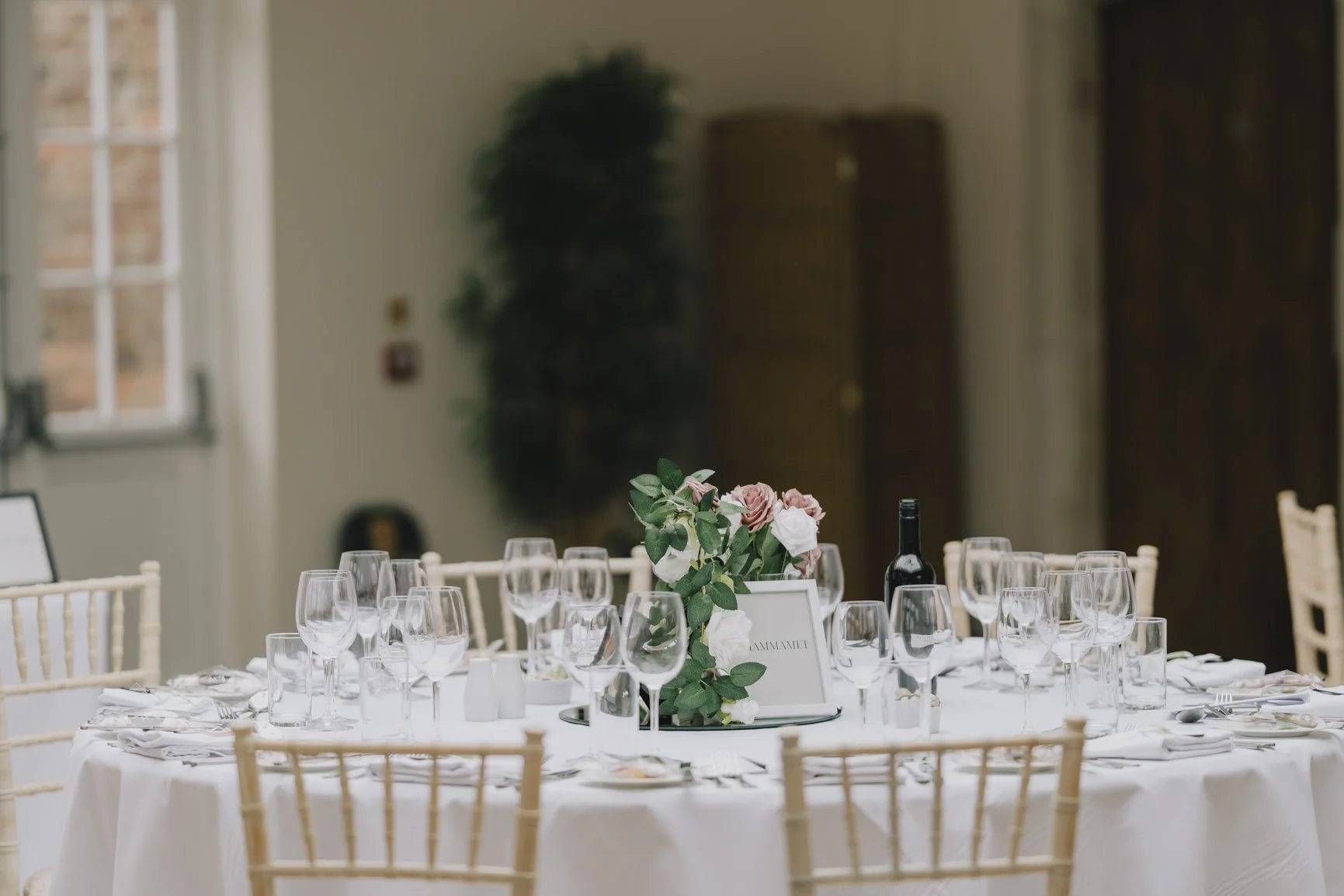 Elegant round table set with glassware, silverware, and a floral centerpiece in a well-lit room Elmhay Park.
