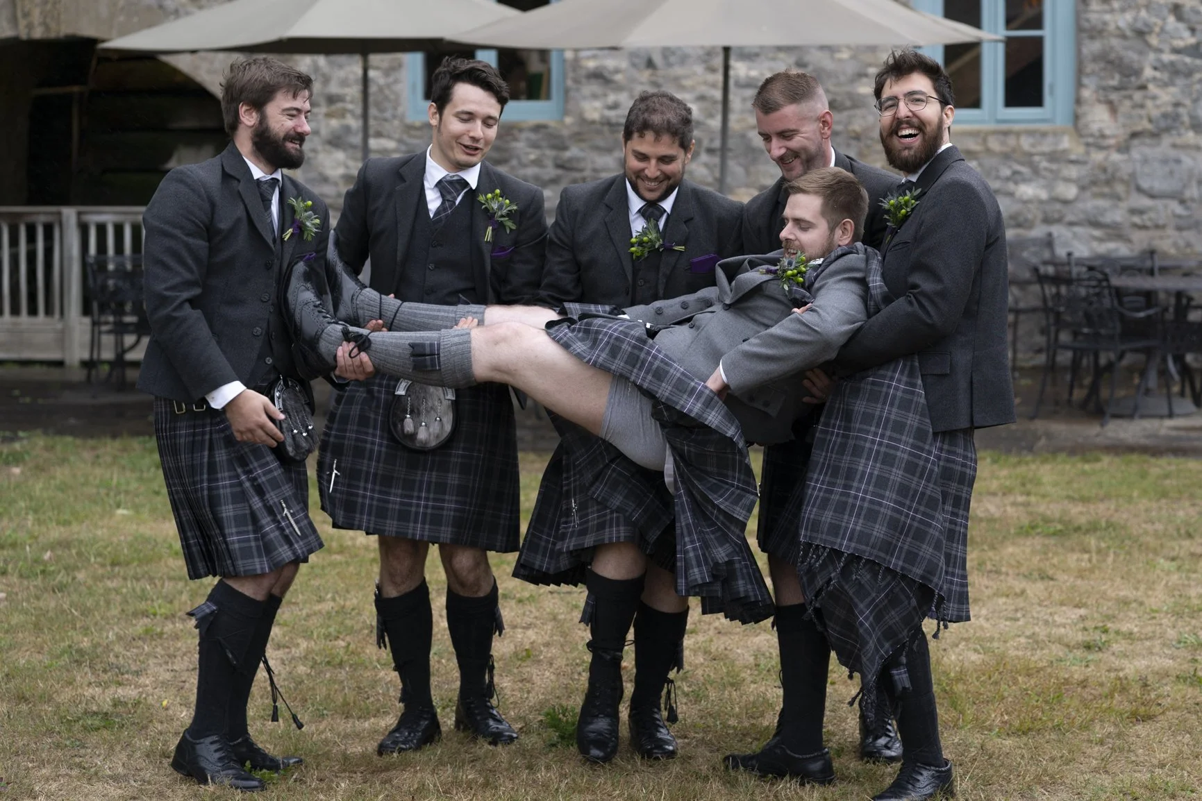 Groom hoisted up with pants showing during his wedding at Priston Mill