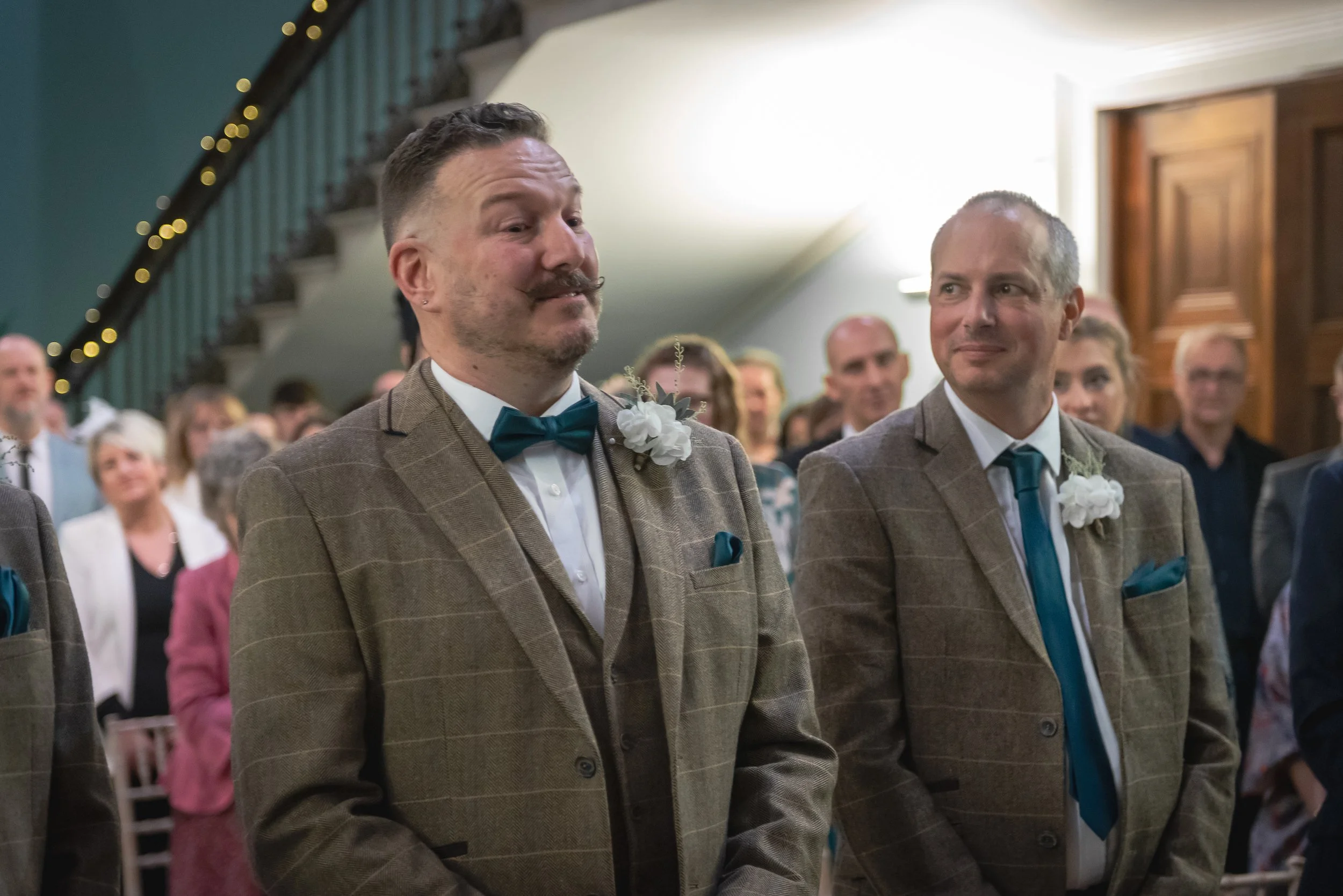 Candid moment of the best man smiling warmly at Andy during the ceremony.
