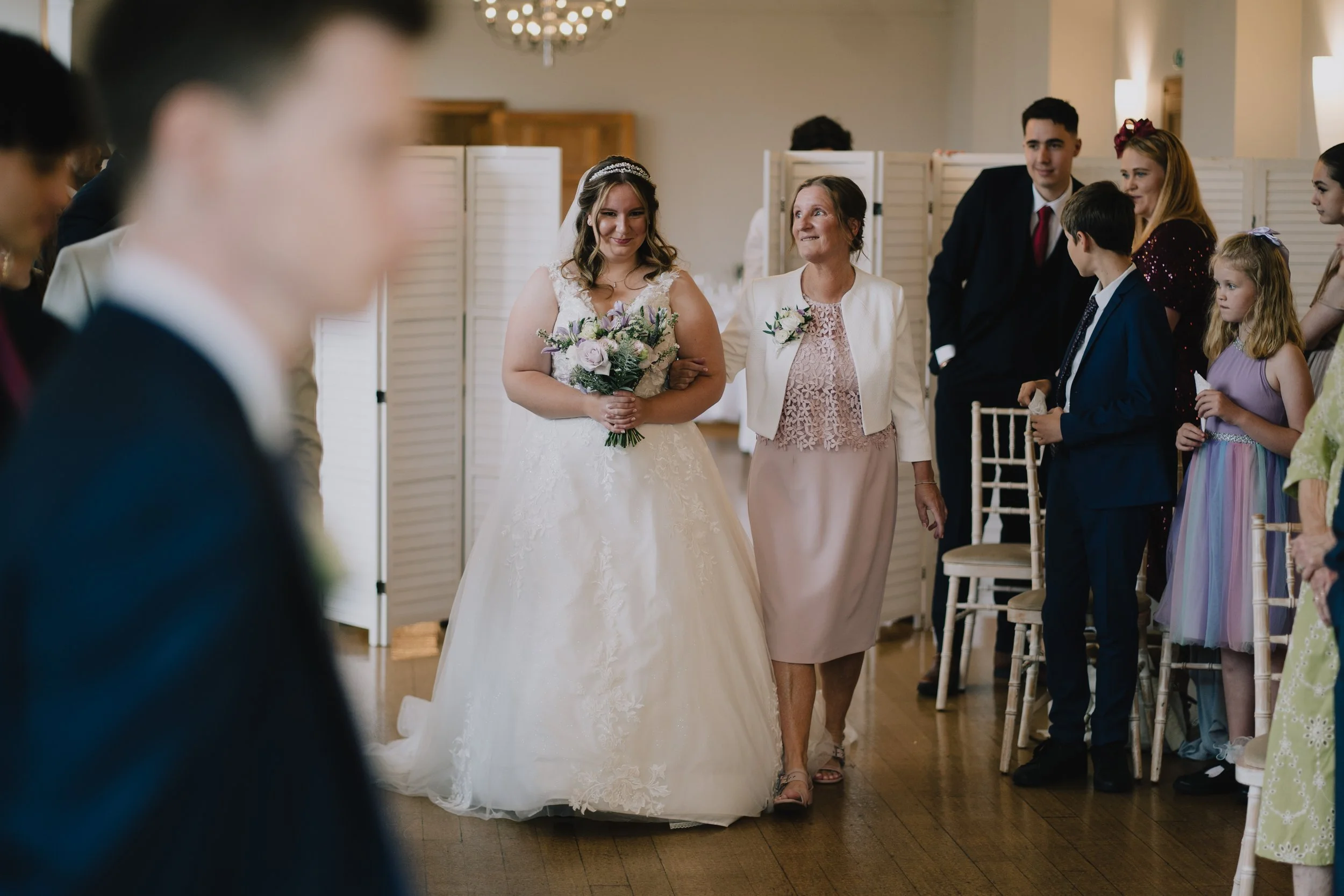 Bride walking down the aisle at Coombe Lodge with her wedding about to begin