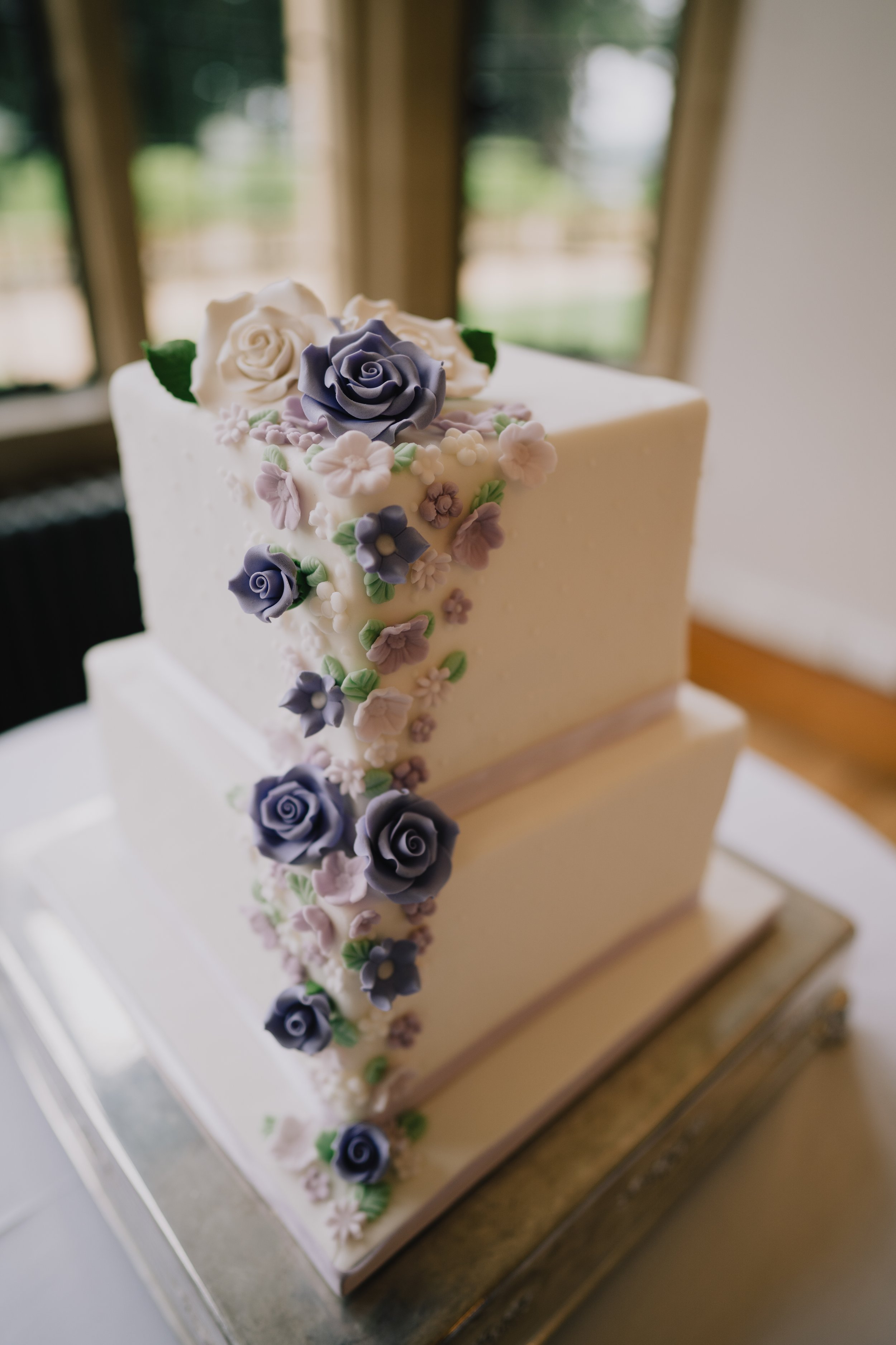Cake at Coombe Lodge decorated with purple icing flowers