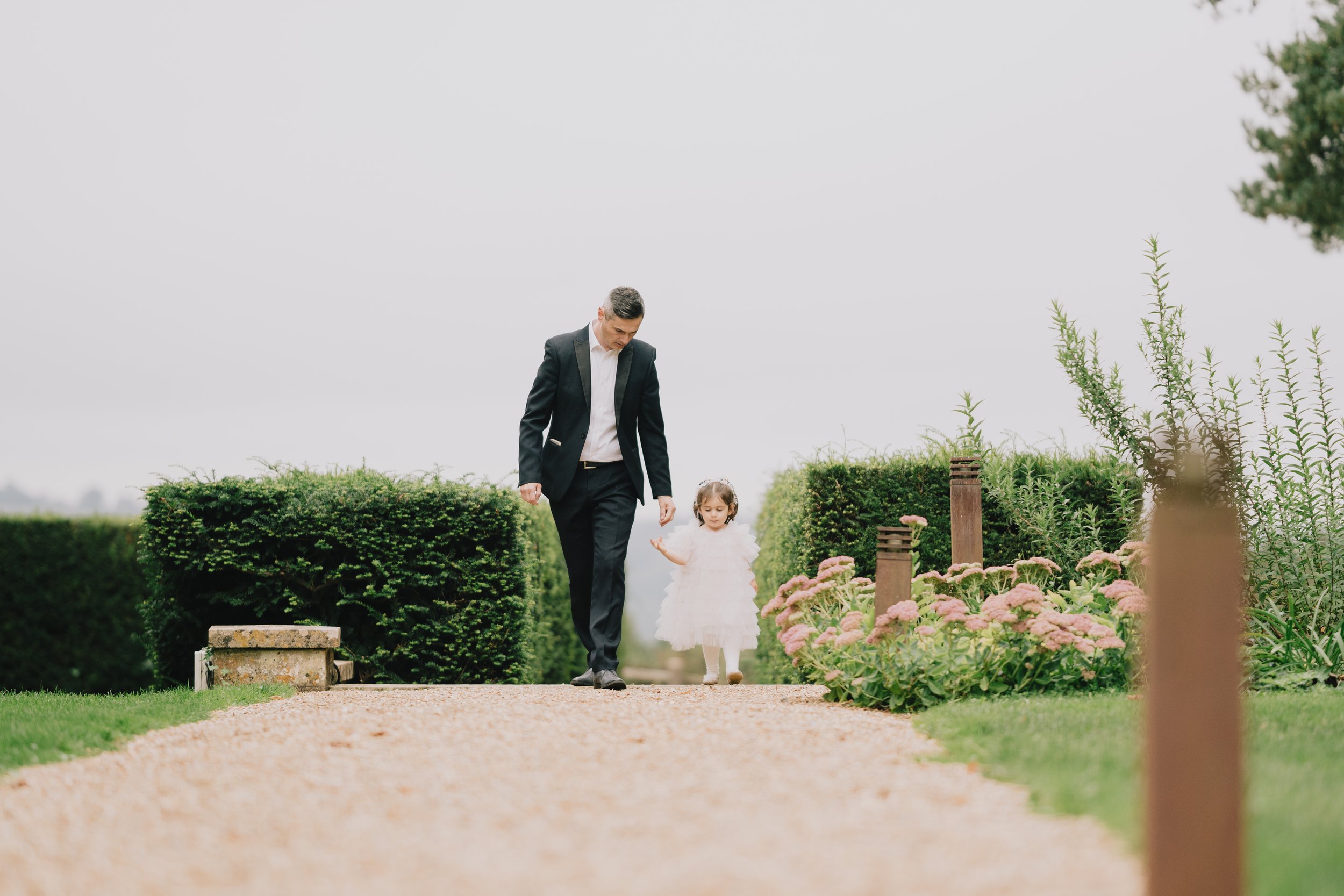 Father and young daughter walking around the grounds of Coombe Lodge
