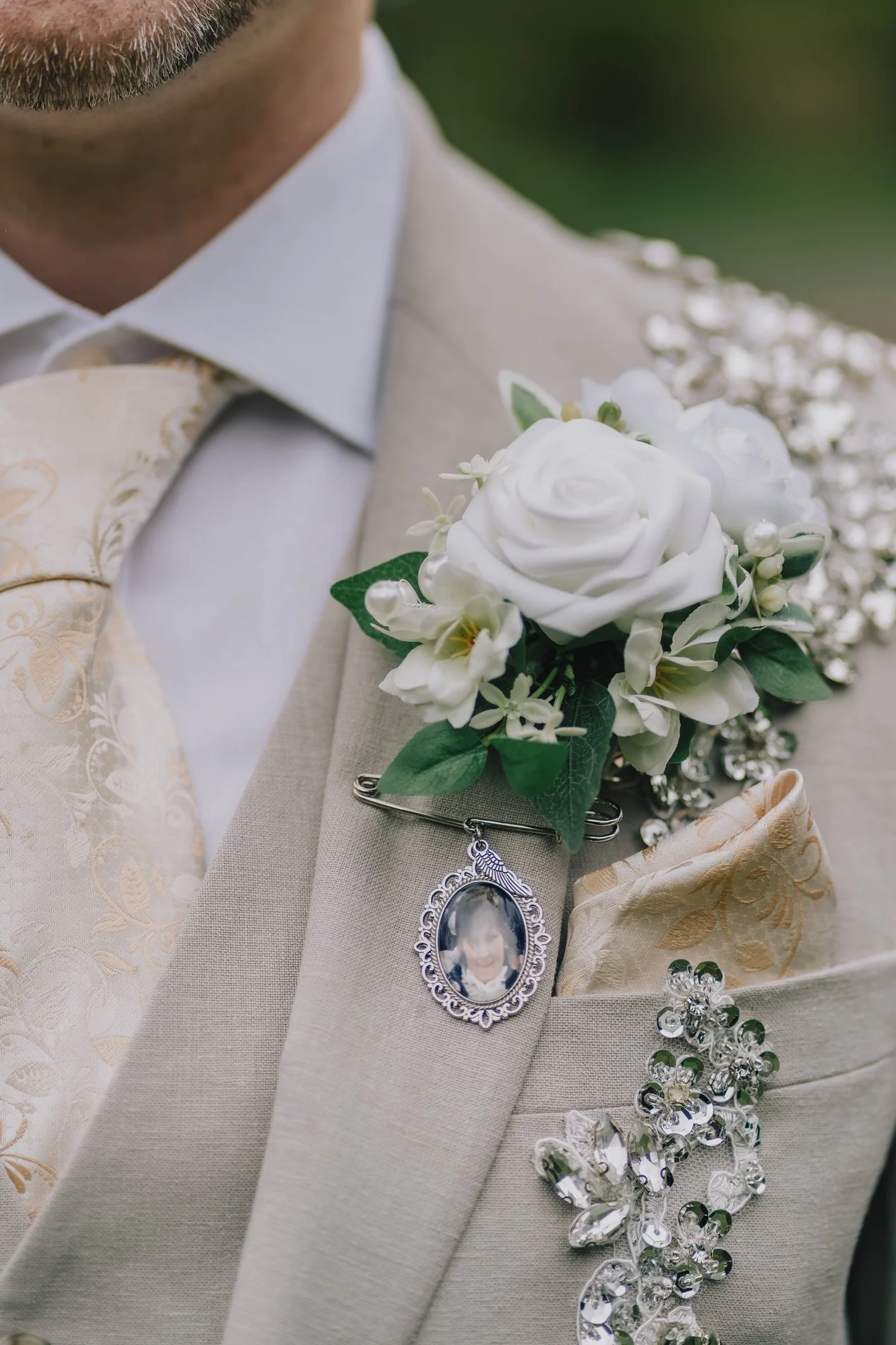 Button hole on groom with a charm of a loved one