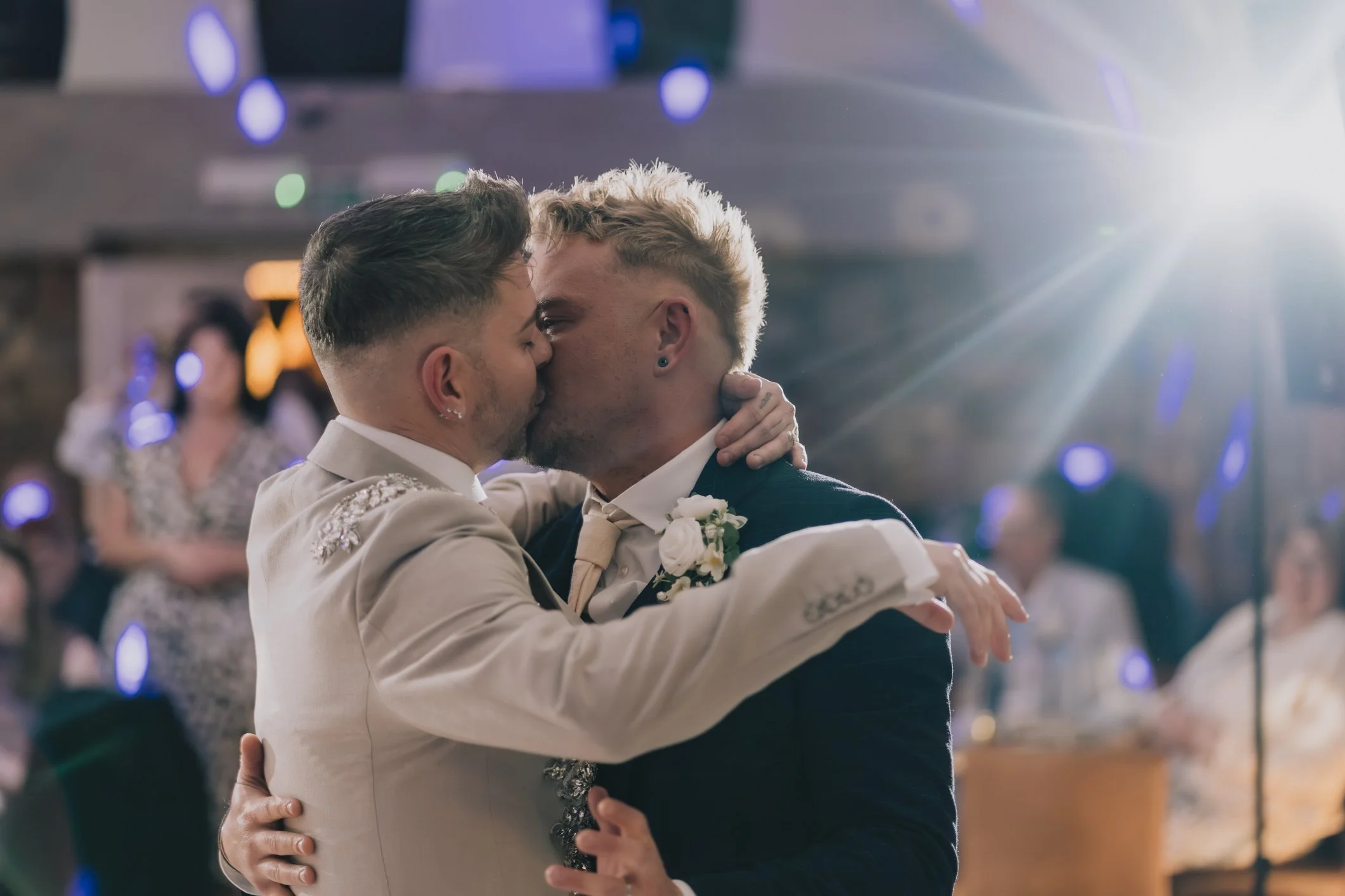 Two grooms kiss during first dance