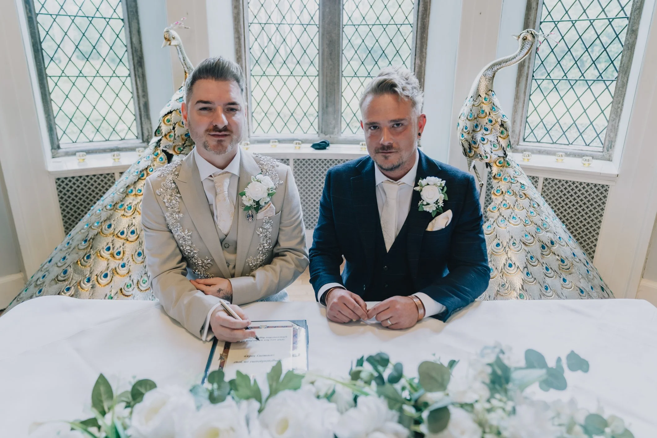 Two grooms smile after their ceremony at Clearwell Castle
