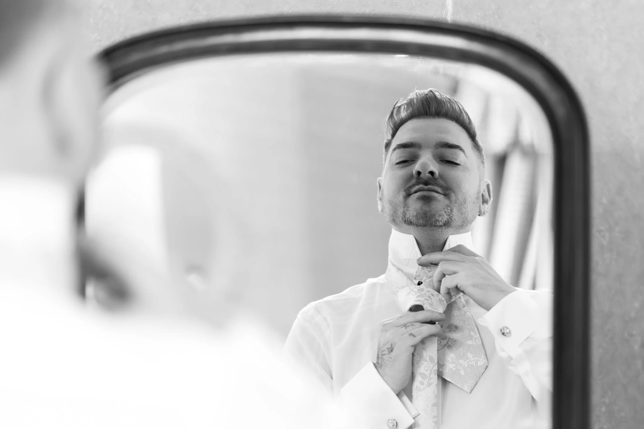 Groom getting ready for this wedding at Clearwell Castle by doing his tie