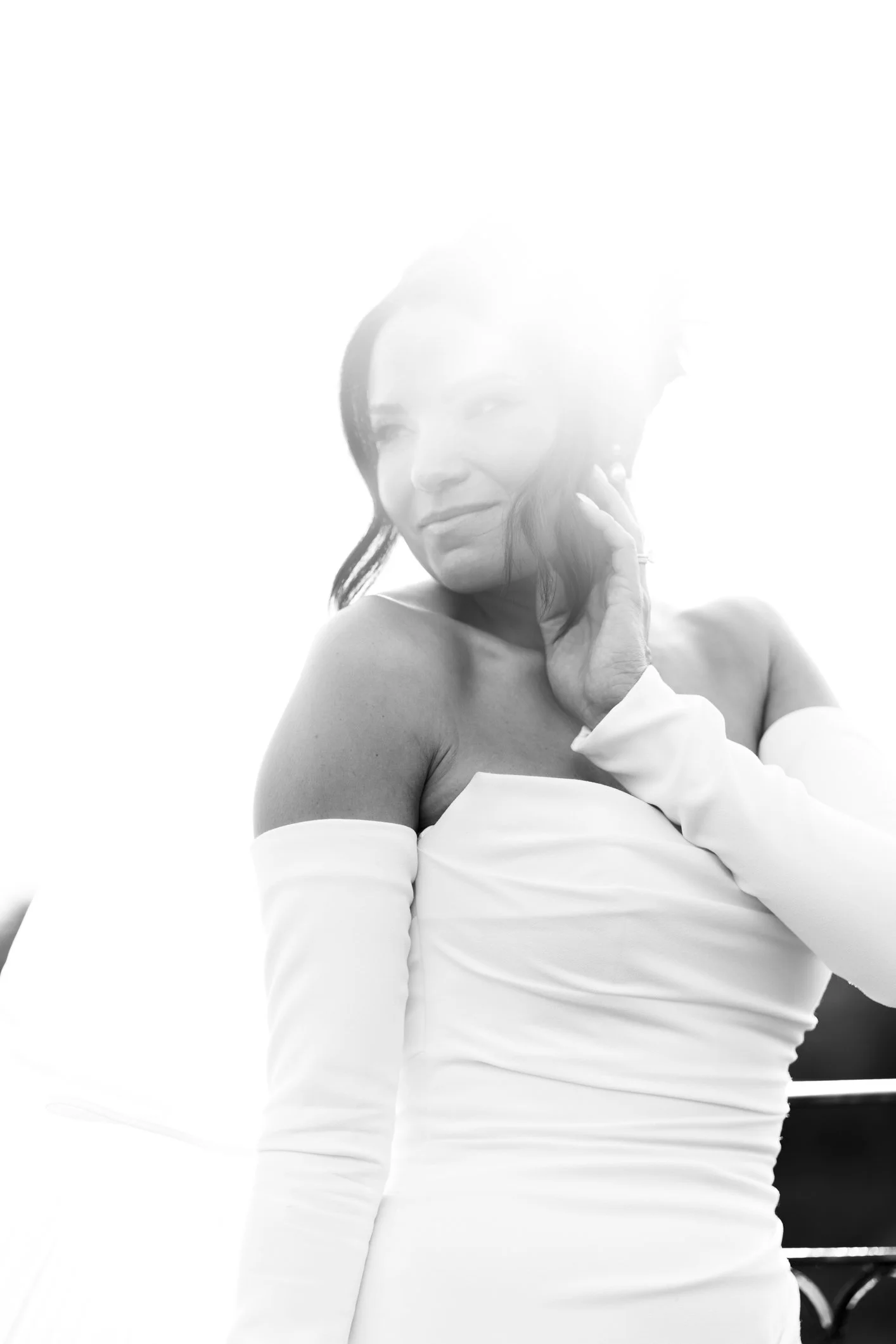 Black and white of bride with sun flare beaming down