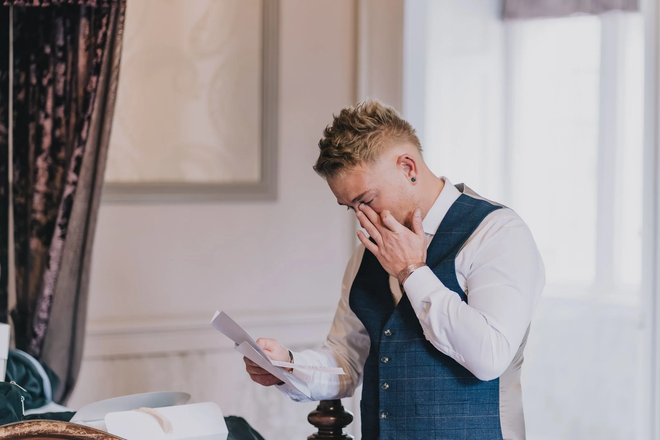 Groom reading a note from his husband-to-be at Clearwell Castle