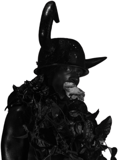 Person wearing a Viking helmet and surrounded by leaves, eating a slice of pizza.