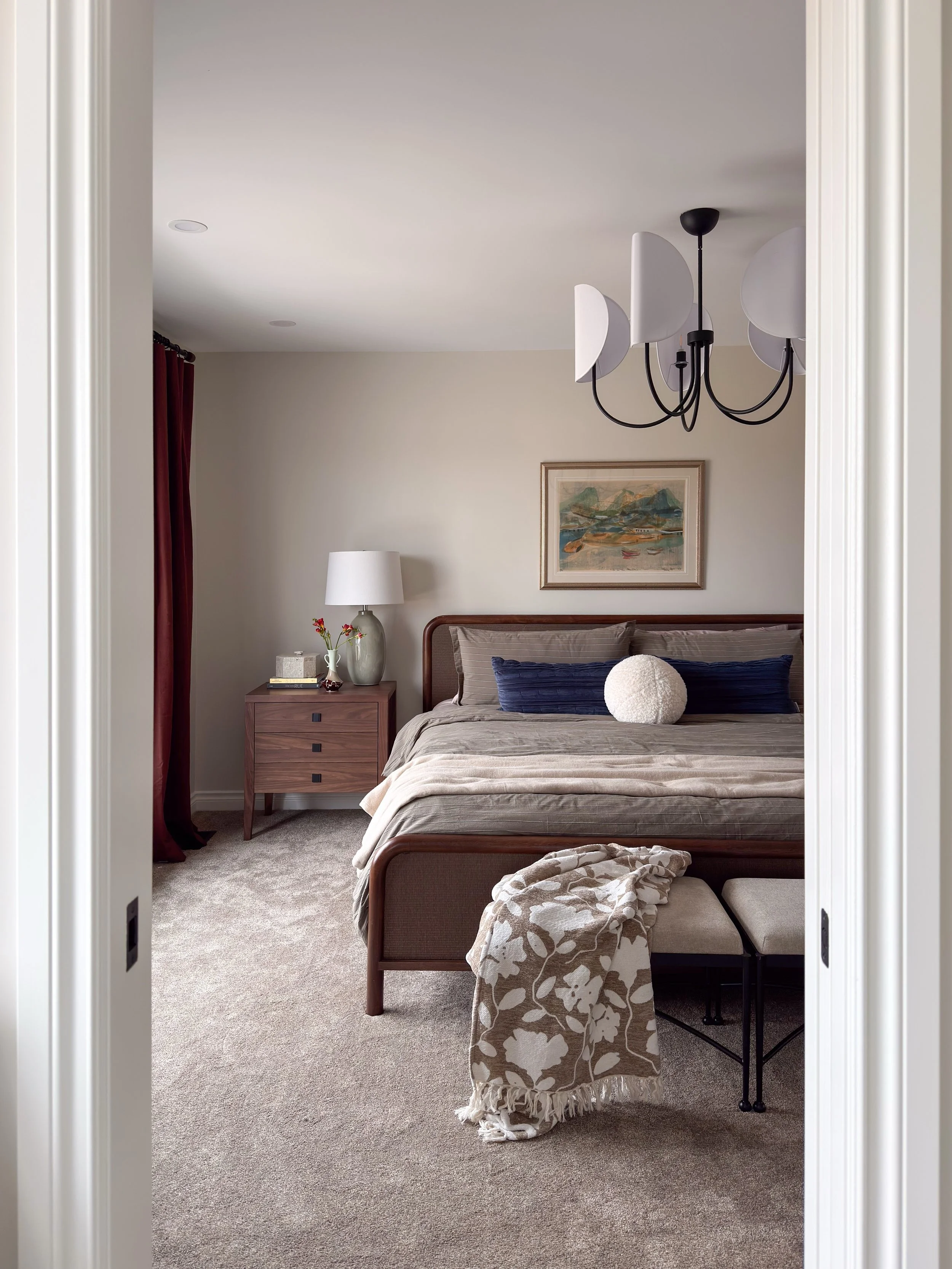 A dreamy Primary Bedroom that mixes creamy walls with rich wood tones and soft hits of blues and greens for a restful retreat. That amazing painting from the 1960&rsquo;s helped to inspire the color palette. The vintage yellow rotary phone is just th