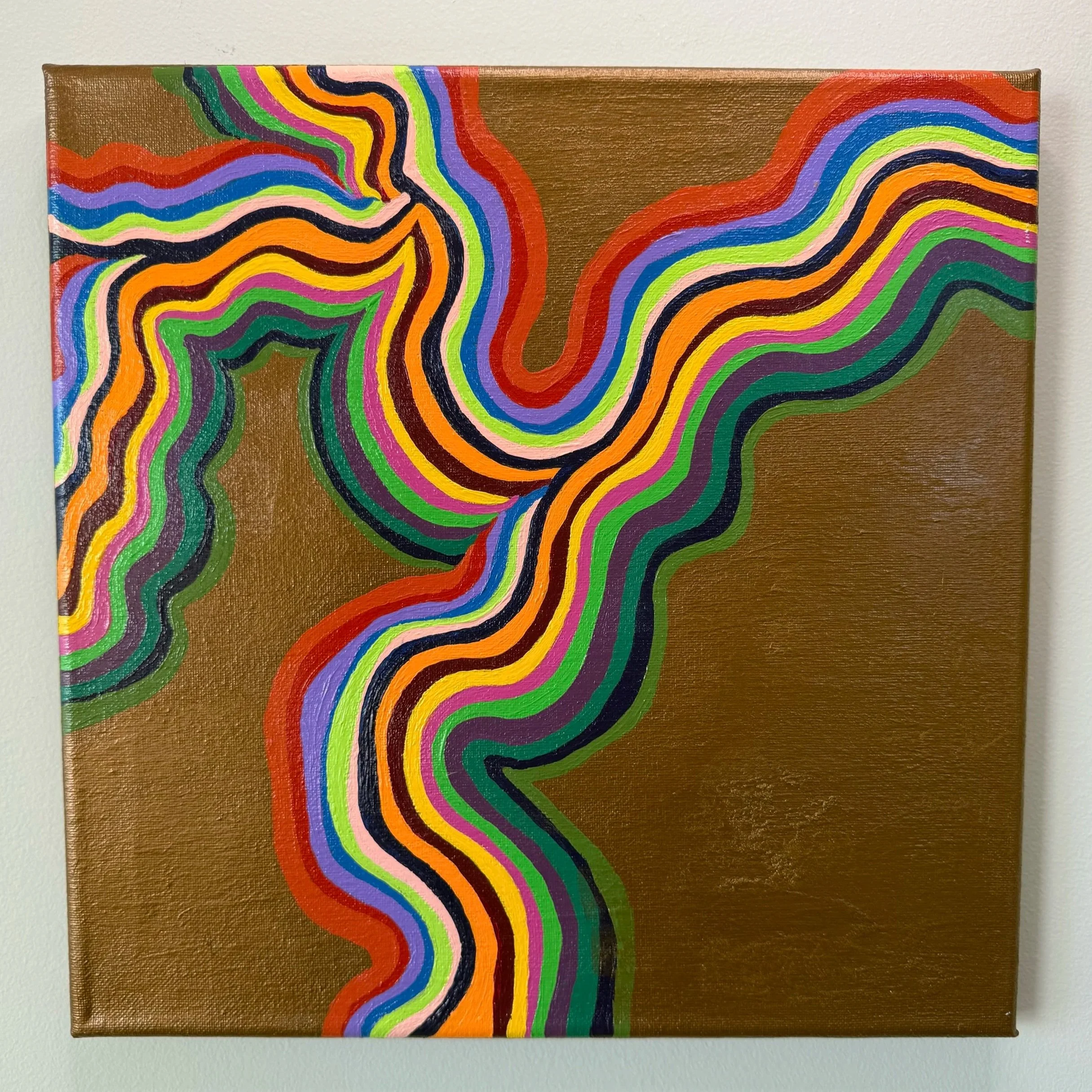 A painting on a canvas features colorful, wavy lines on a gold background, creating an abstract pattern.