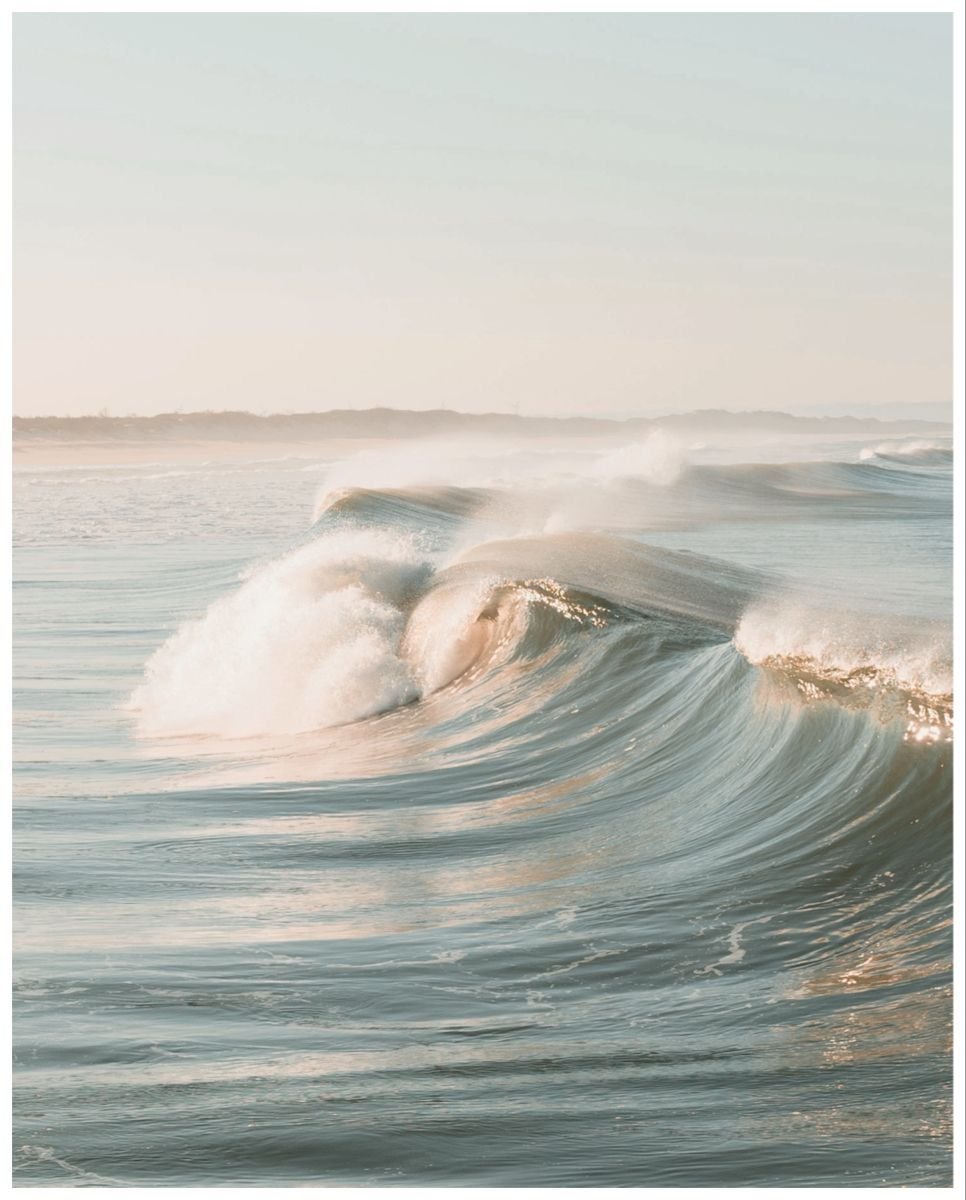 Waves crashing in the ocean during daytime with a blurred horizon in the background.
