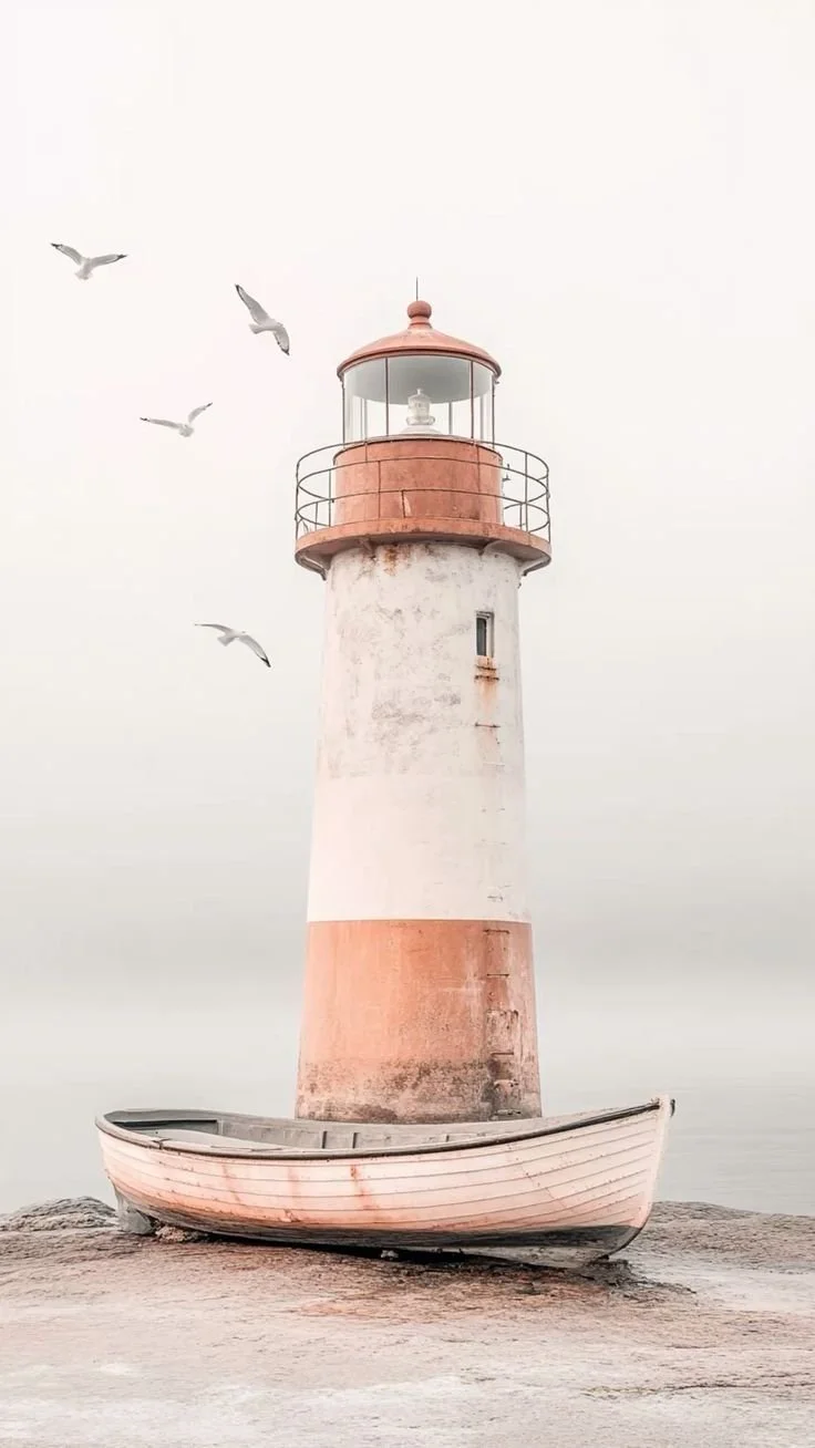 A lighthouse surrounded by water and seagulls flying nearby on a cloudy day.