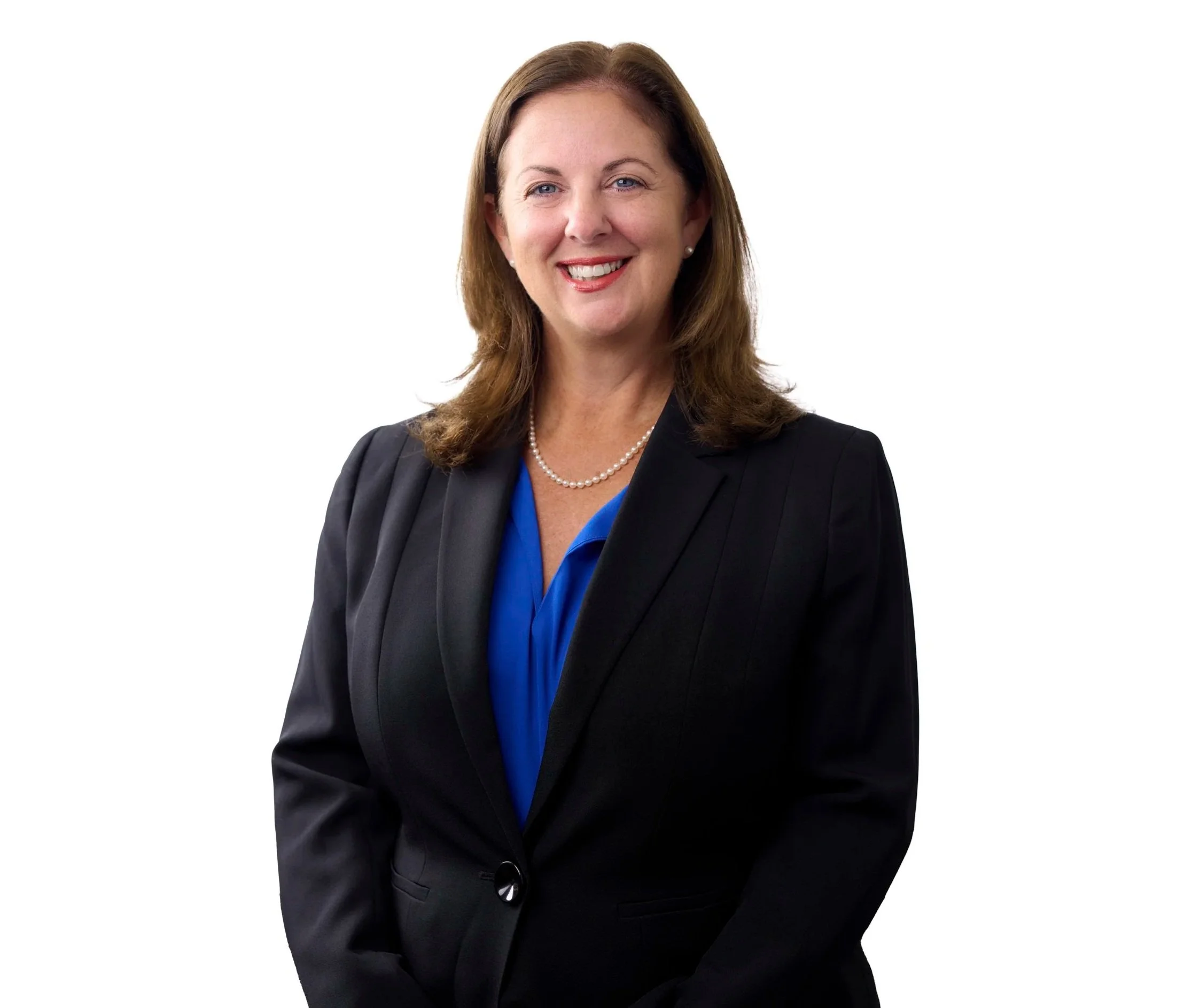 Headshot of a woman with brown hair, wearing a dark blazer, a blue blouse, and a pearl necklace, smiling against a white background.