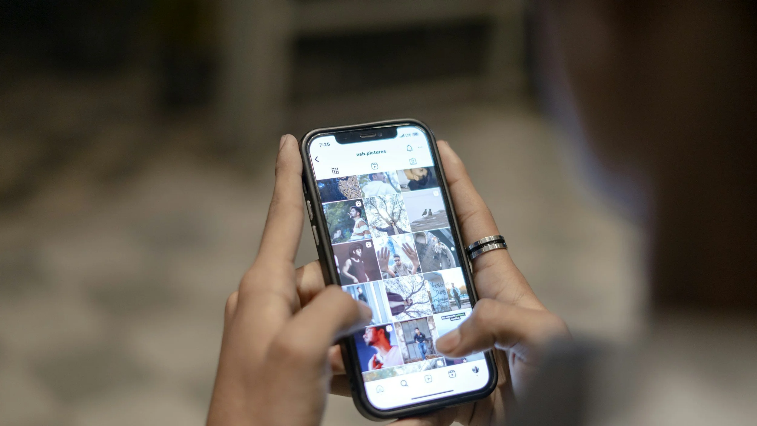 Person holding a smartphone and browsing a photo gallery app.