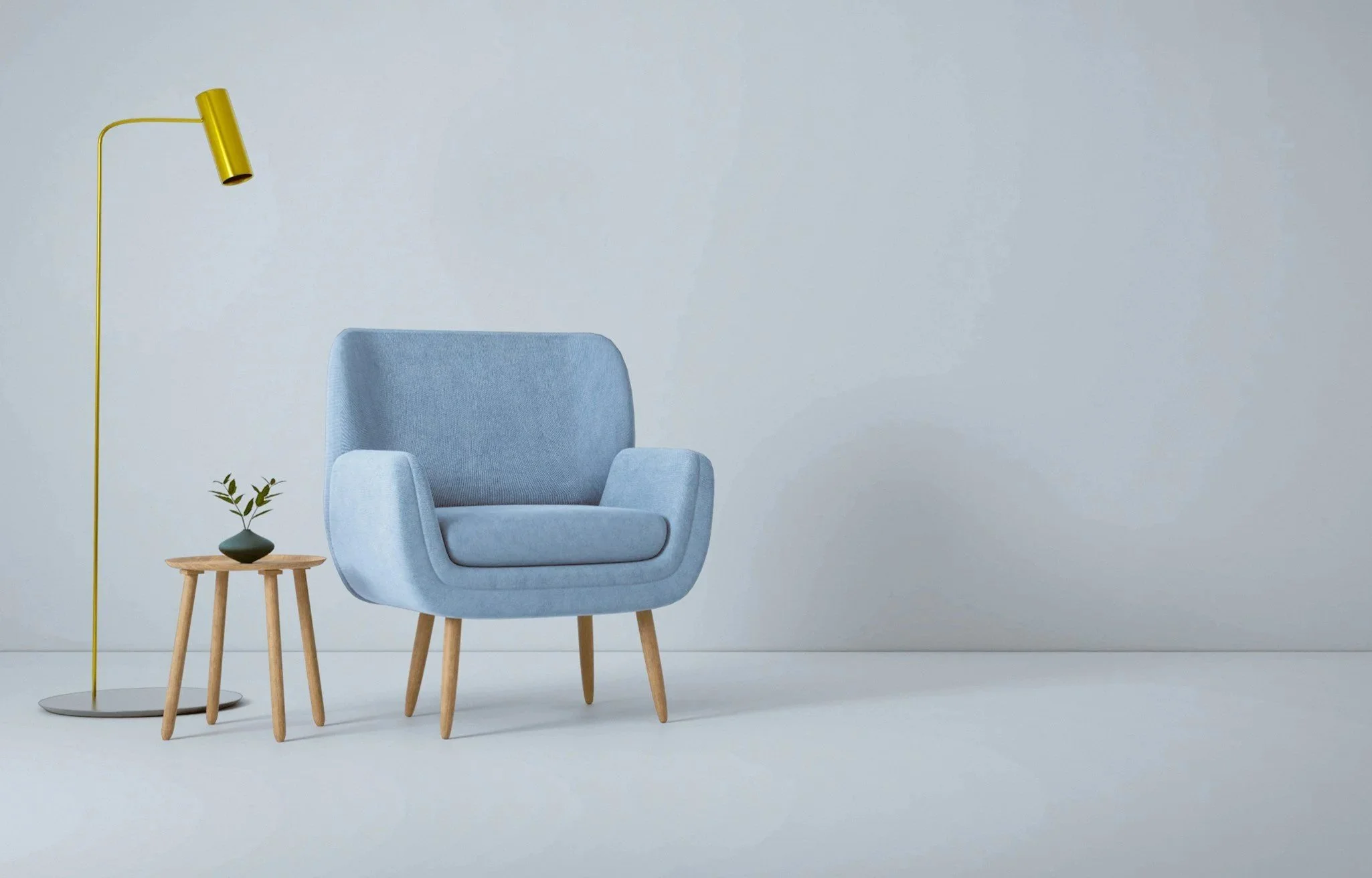 A modern living room corner featuring a light blue armchair with wooden legs, a small round wooden side table with a green decorative vase holding a few branches, and a tall yellow floor lamp with a cylindrical shade against a plain white wall.