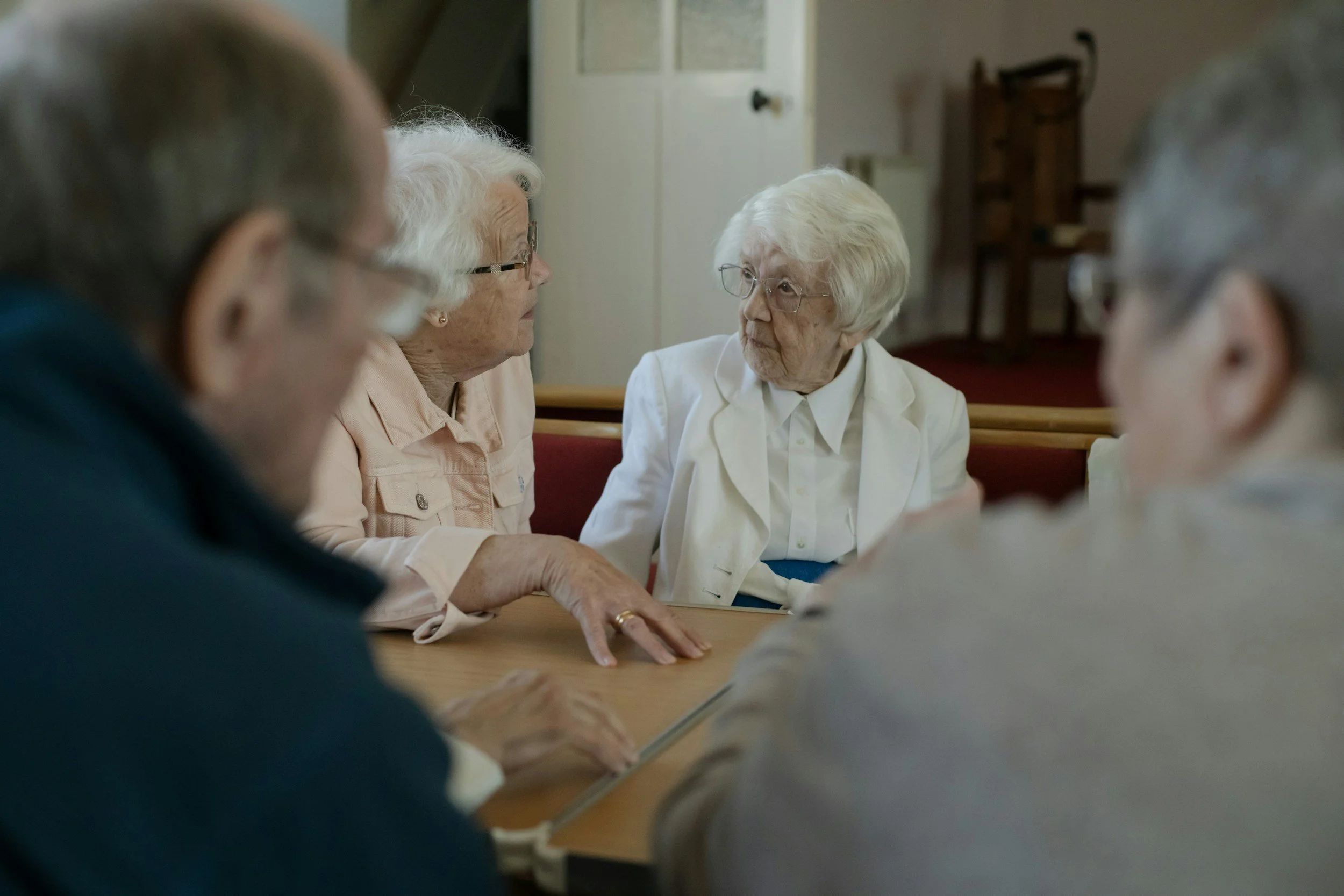 Older women talking together around a table