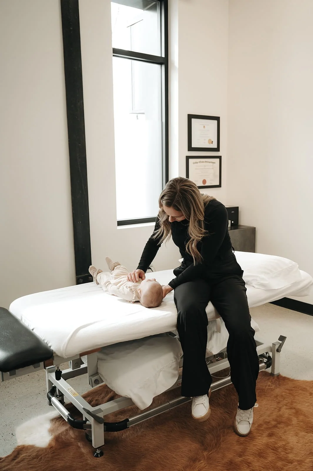Kensey Lunn performing osteopathic care on an infant at Holm Collective, Lacombe, AB
