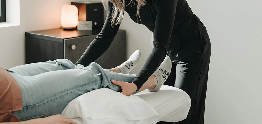 A person receiving osteopathic treatment from Kensey Lunn on a massage table at Holm Collective, Lacombe AB.