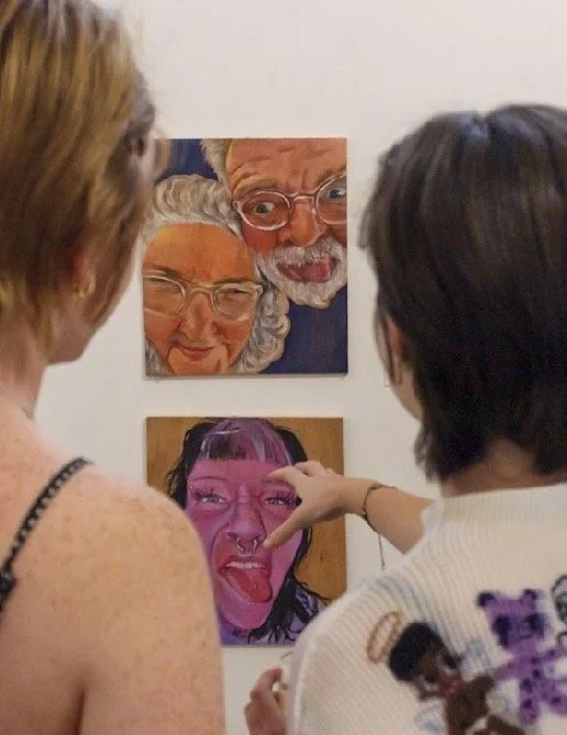 two people discussing portraits by Poppy Holmes