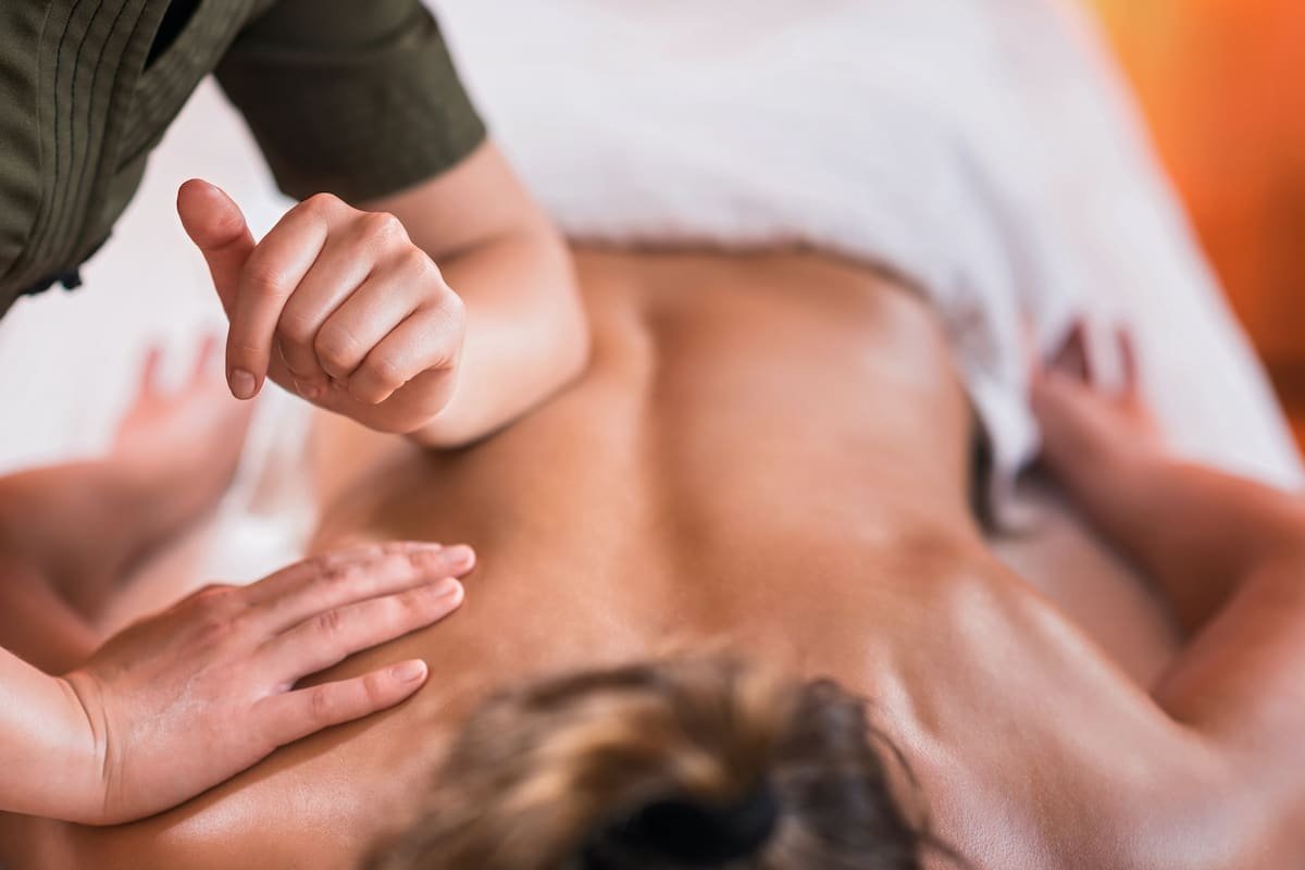 Person receiving a back massage from a massage therapist.