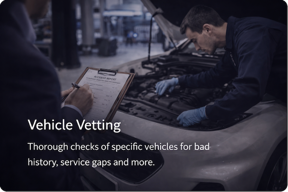 A mechanic inspecting an engine with a technician writing notes on a clipboard at an auto service center.