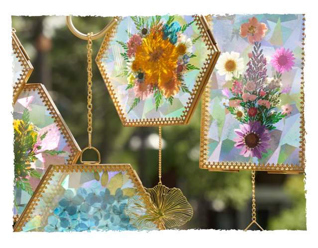 Decorative lanterns with pressed flowers hanging outdoors.