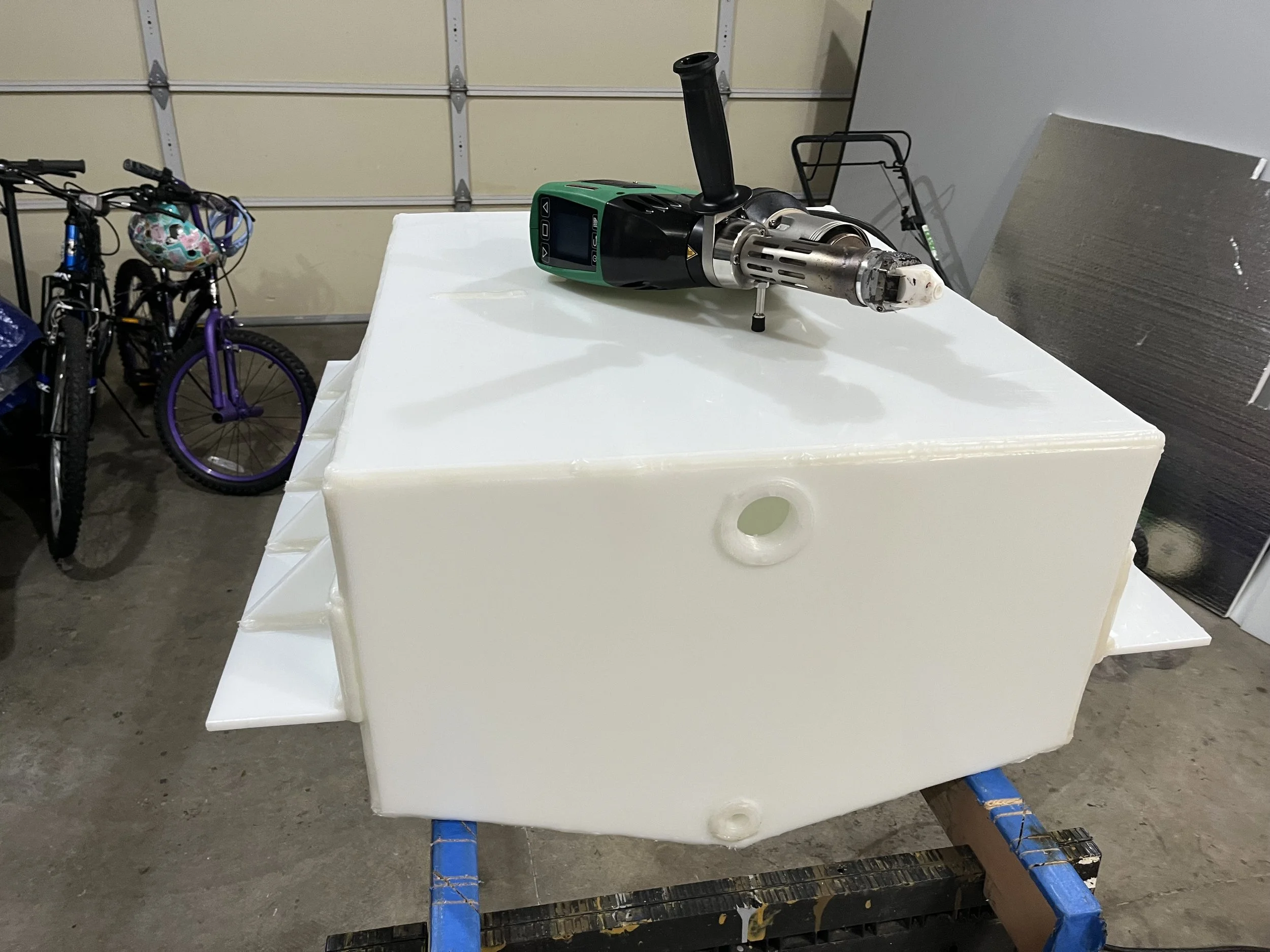 A 40-ish gallon welded HDPE tank showing the "vee" to bit down in a bilge and welded brackets for mounting.
