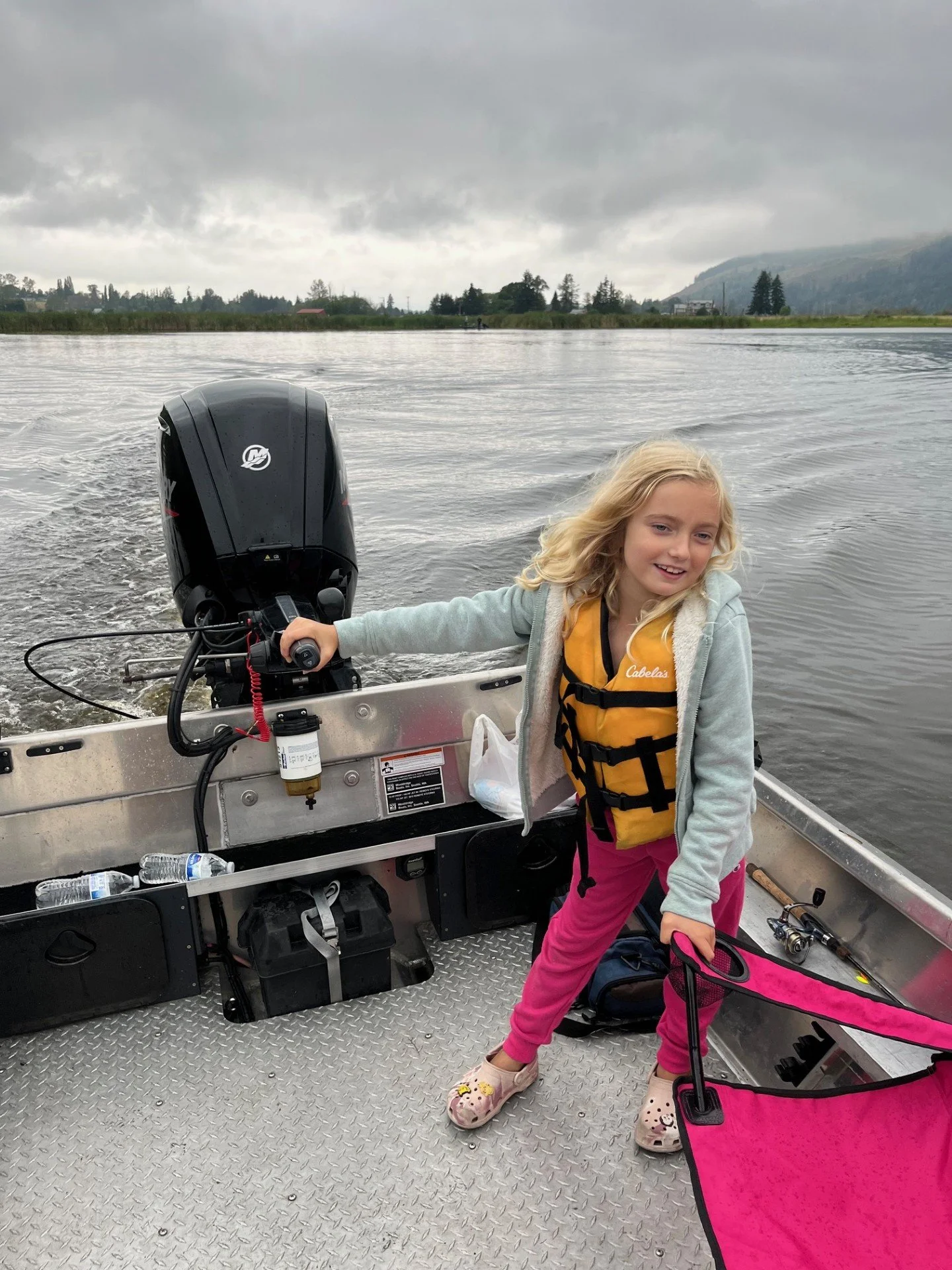 Teaching the future deck hand of Wyman Guide Service how to operate the boat while on the Skagit River.