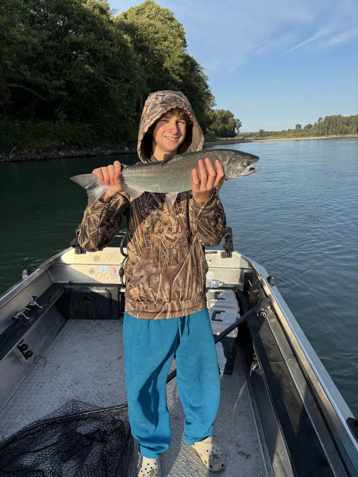 The son of Wyman Guide Service holding up a nice Coho caught on the Skagit River.