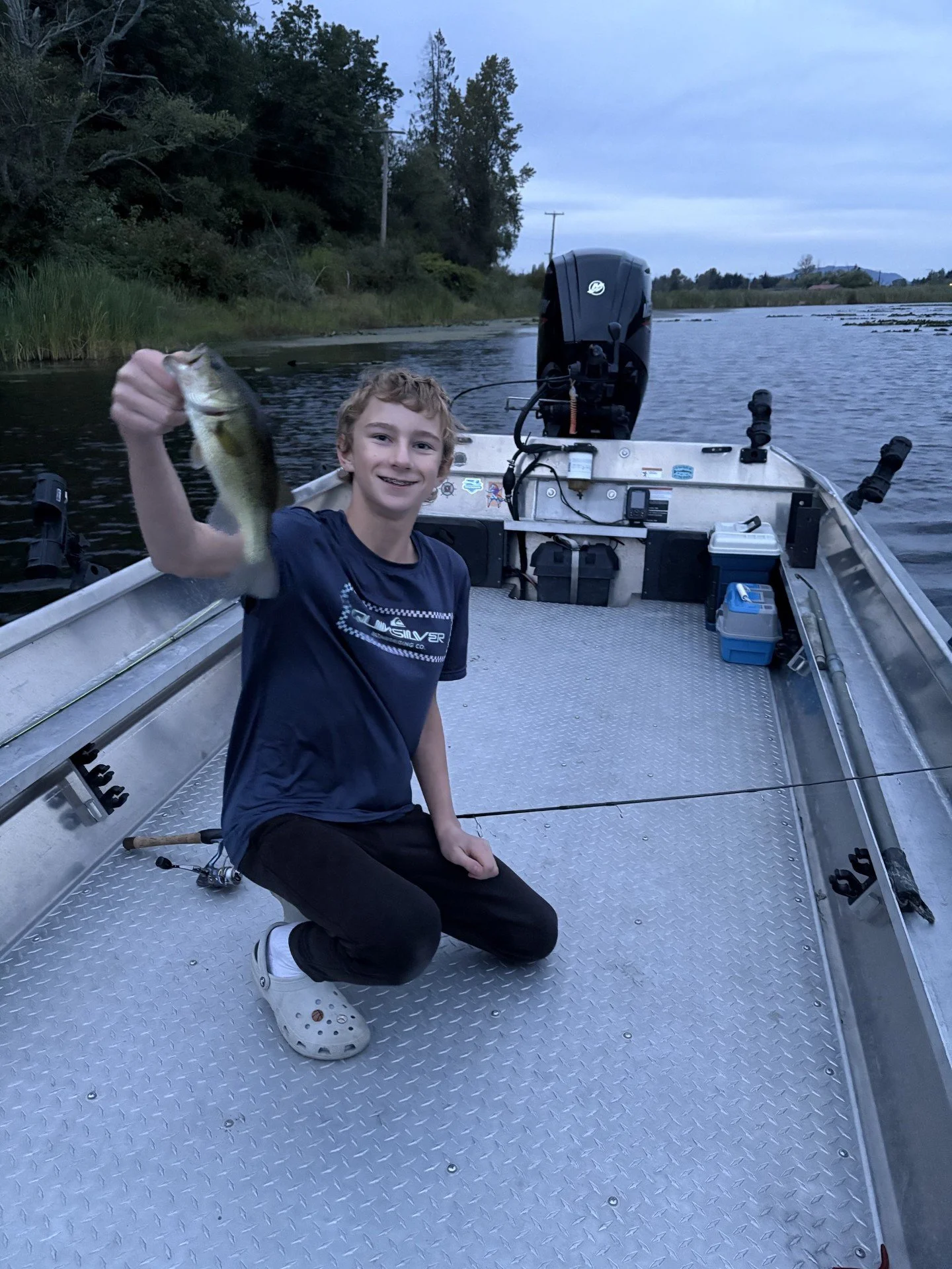 My son holding a bass he caught during a fishing trip in Skagit County.
