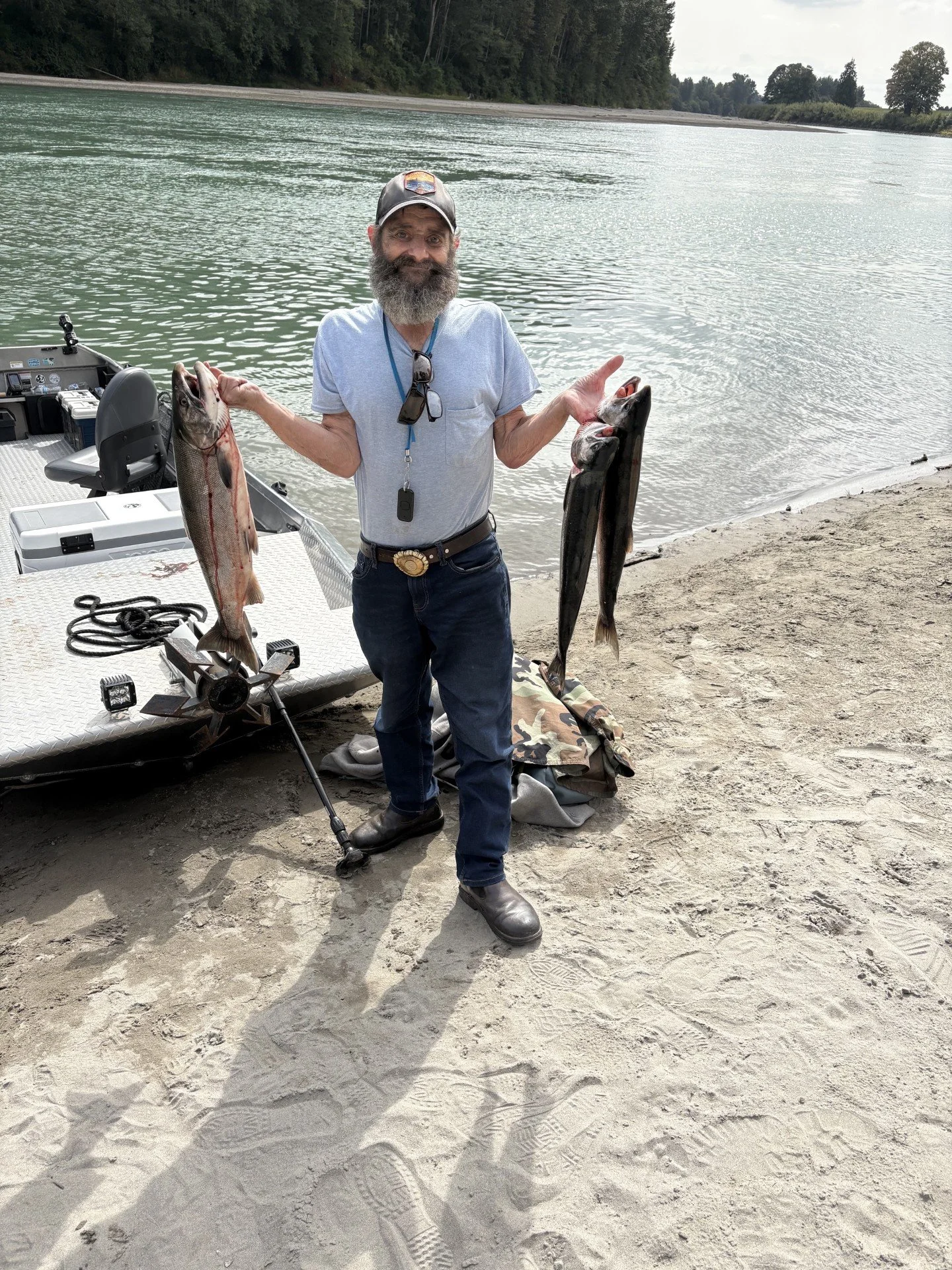 A client of Wyman Guide Service with three coho caught on the Skagit River.