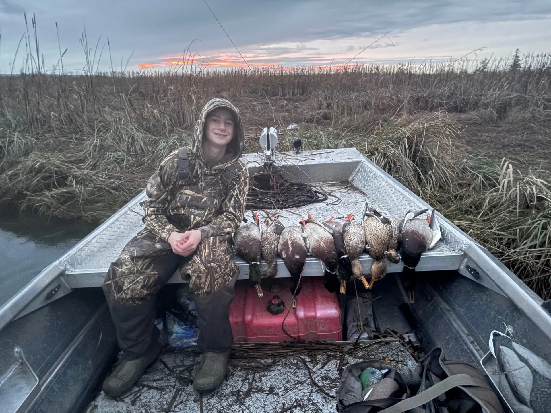 Tyler and a line of ducks after a fast evening hunt in the Skagit wetlands.