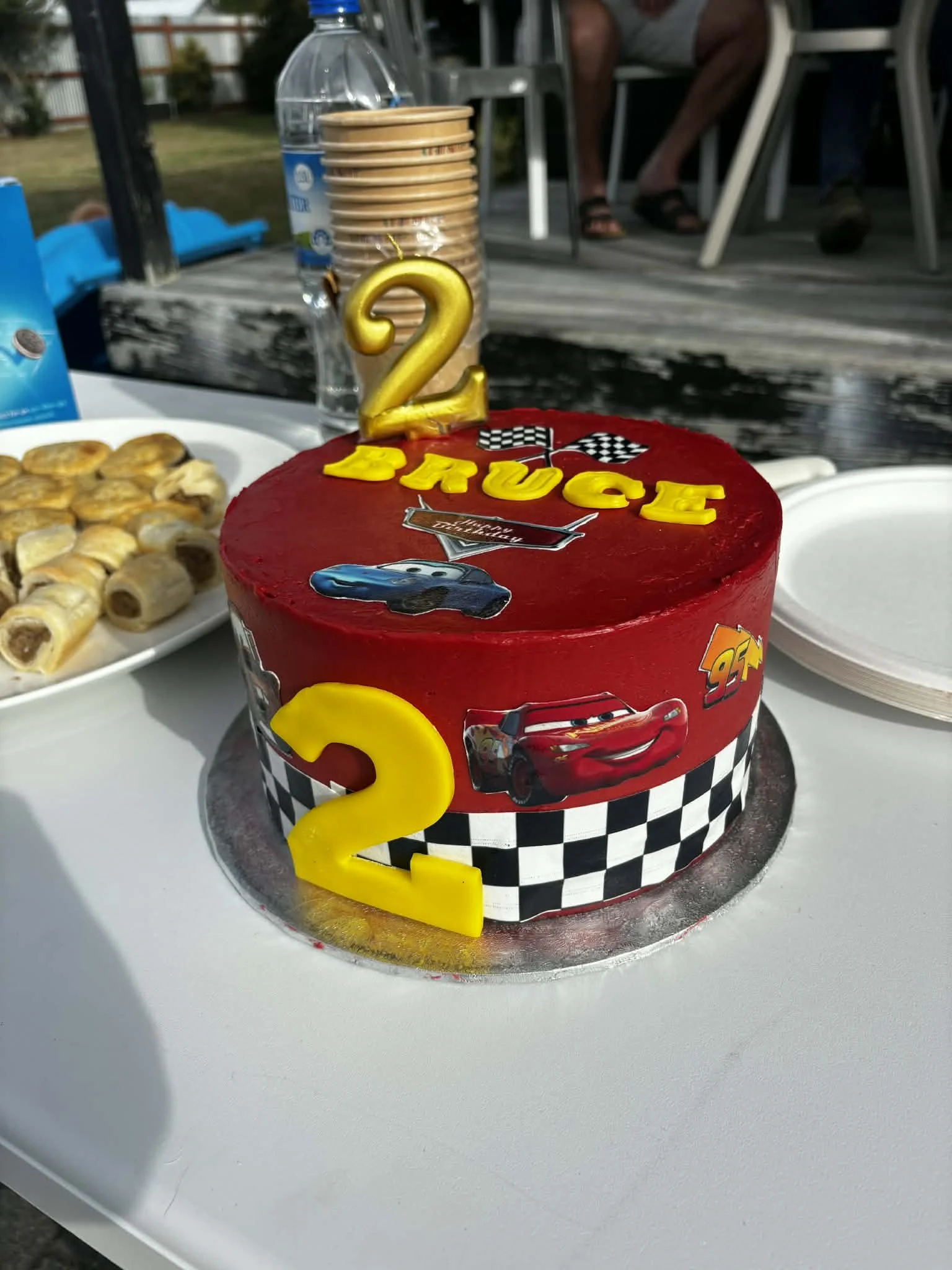 A bold Lightning McQueen-themed cake finished in vibrant red buttercream, featuring racing details, checkered flag accents, and a detailed topper. Designed to capture the excitement of the racetrack—perfect for any car-loving kid.