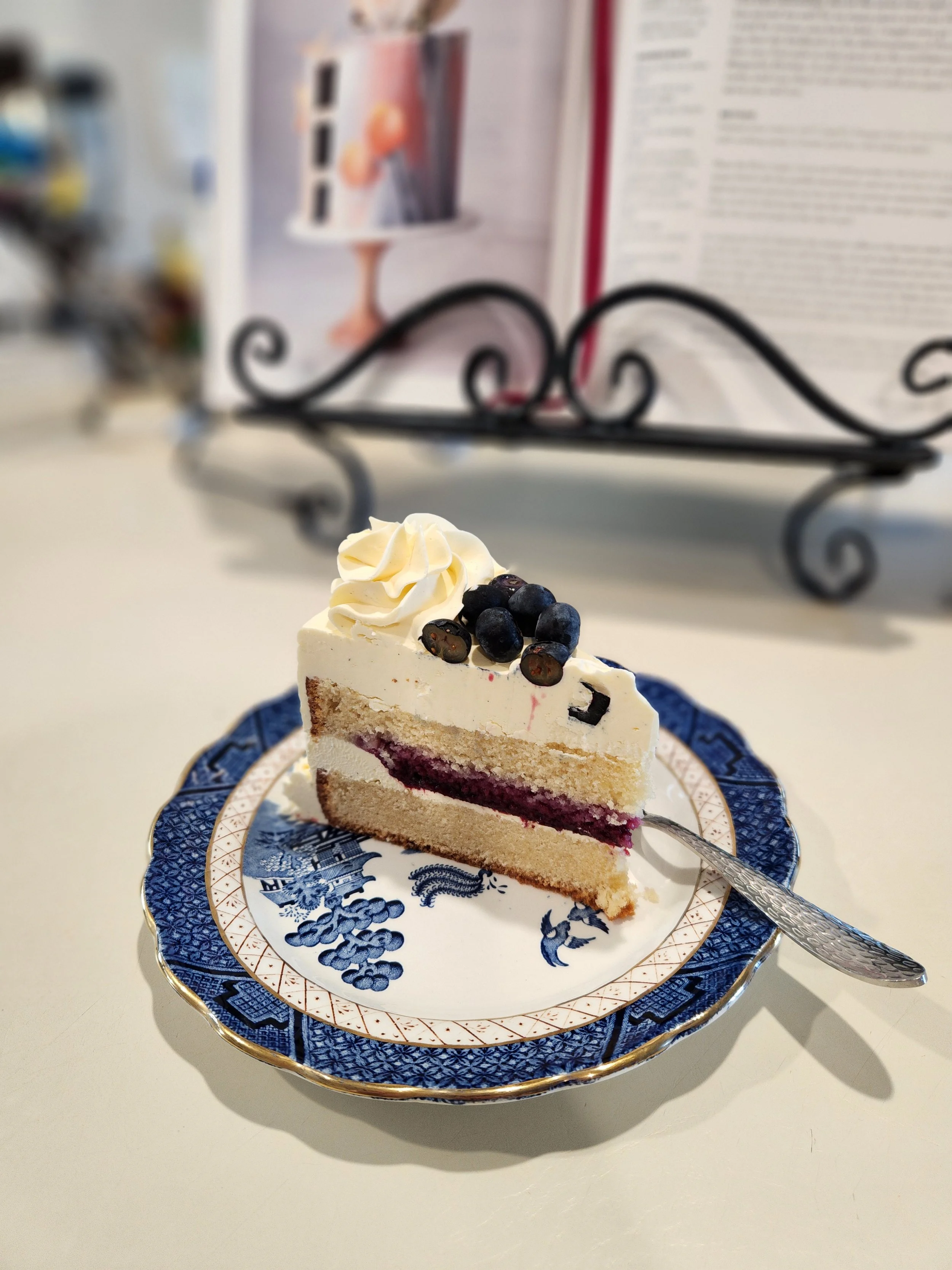 A slice of vanilla cake with blueberry compote filling.