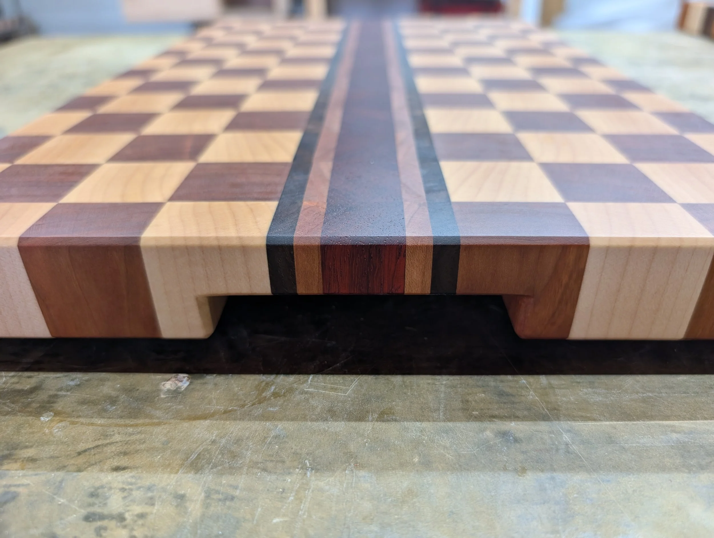 Our end grain cutting boards are crafted from a variety of premium, locally sourced hardwoods - each piece showcasing the unique grain patterns and natural color of the lumber. Designed for both durability and visual impact, these boards highlight th