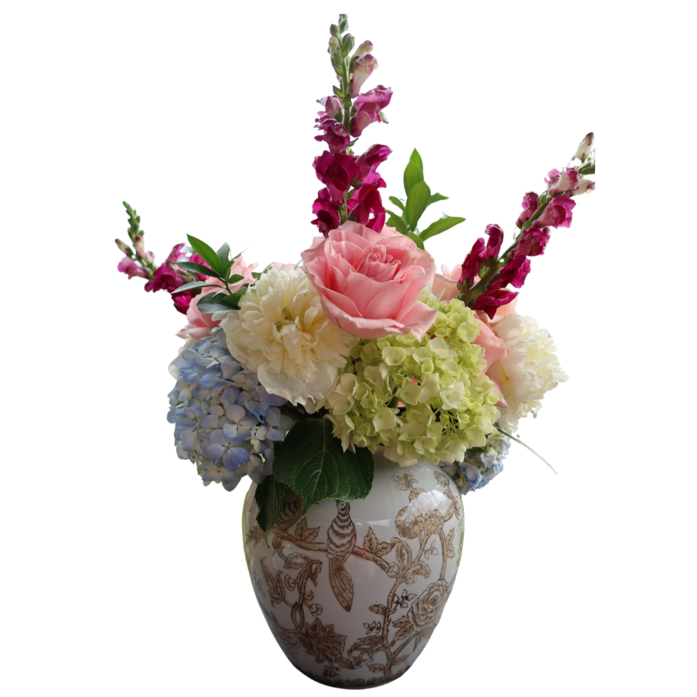 Arrangement of pink roses, white hydrangeas, purple gladioli, and greenery in a decorative vase