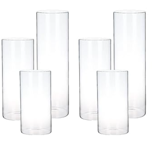 Six empty, clear glass tumblers of varying heights arranged together.