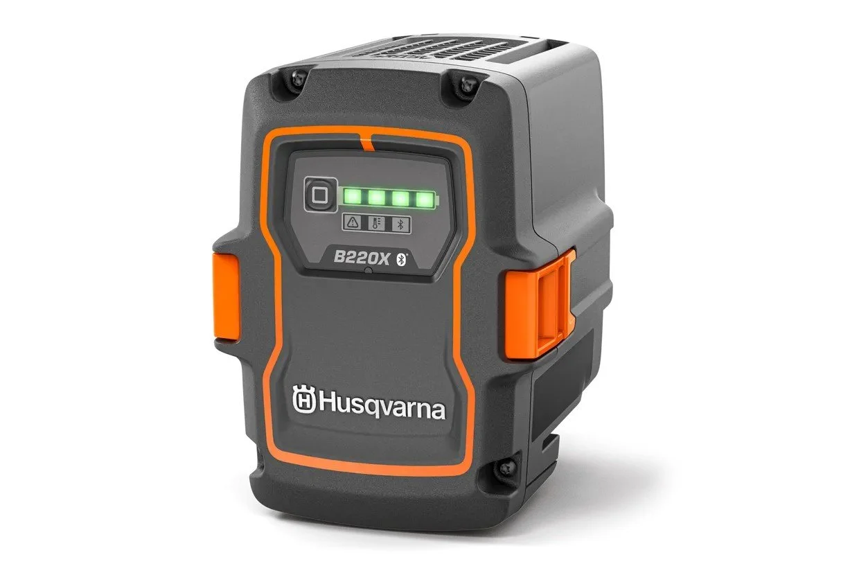 A Husqvarna B220X cordless fence or reciprocating saw with a black and gray body, orange accents, and a digital display on the front.