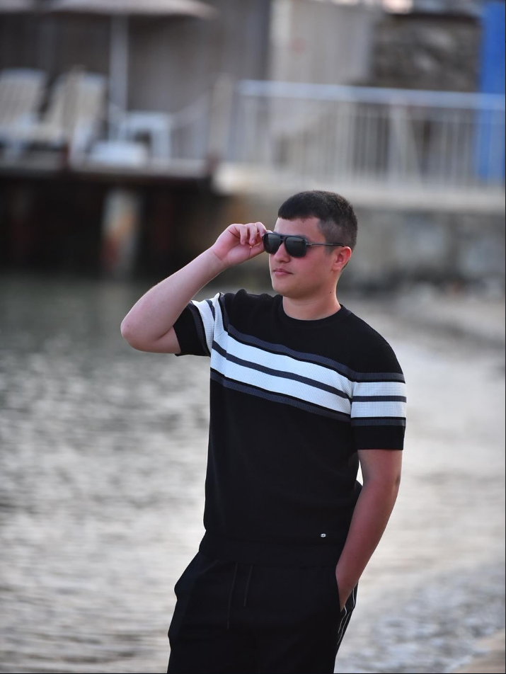 Ahmet Babuşçu, co-founder of GrowFire Studios, standing near the water in a modern casual outfit, representing a clean and minimal lifestyle.