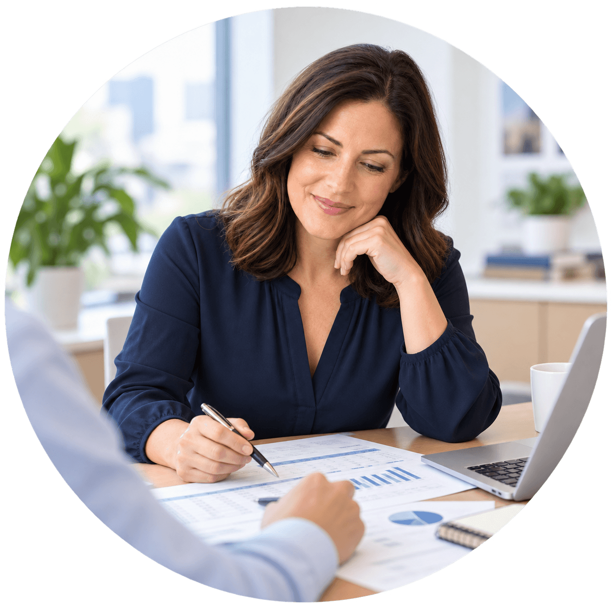 Business owner reviewing financial reports with an adviser at a desk.