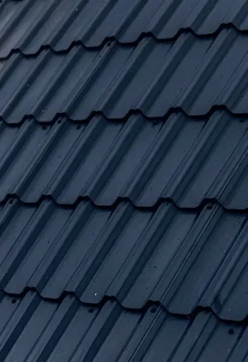 Close-up of a blue metal roof with overlapping wavy panels.