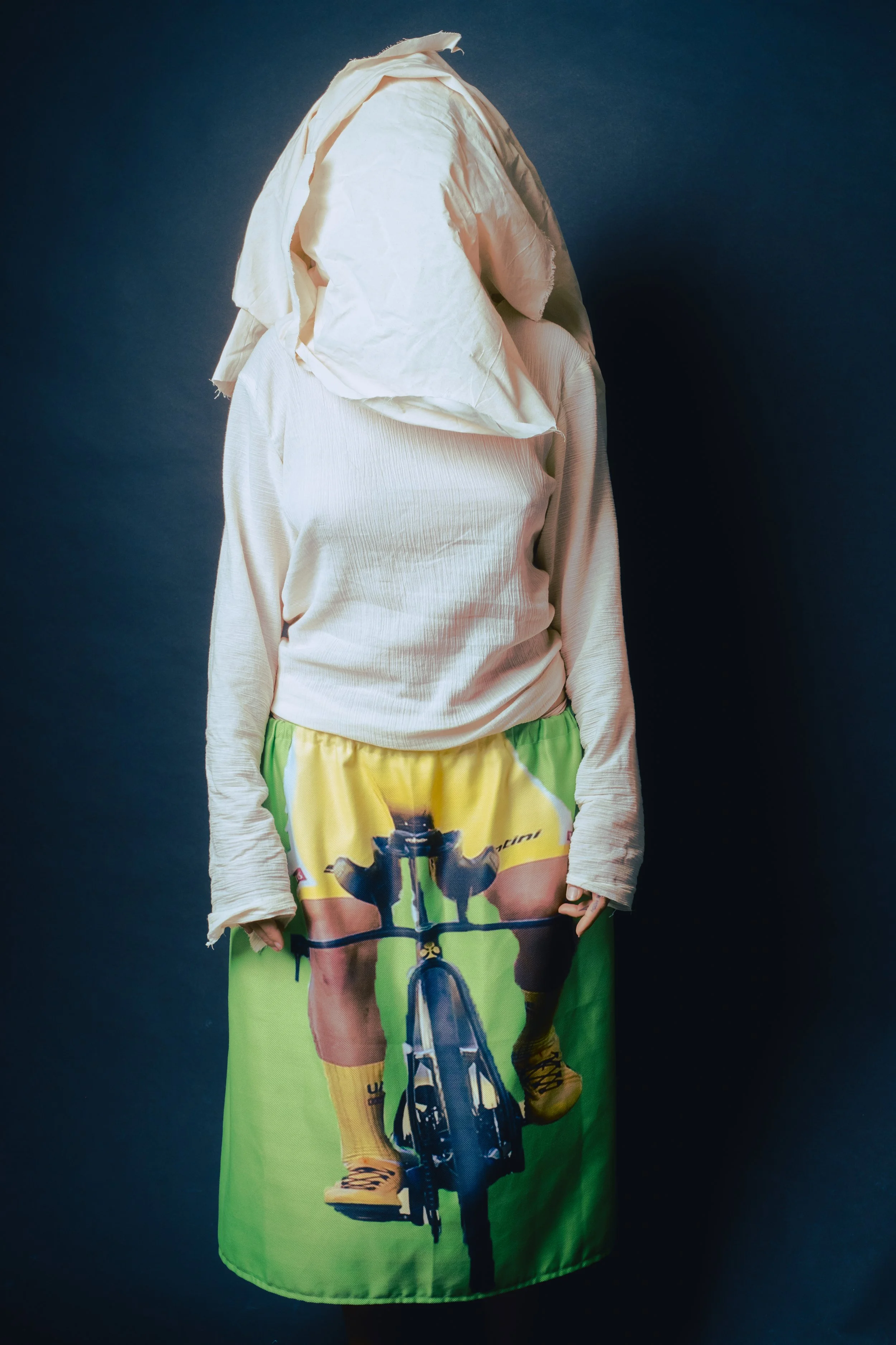 Clothing displayed on a mannequin featuring a white long-sleeve shirt and a colorful skirt with a cyclist print.