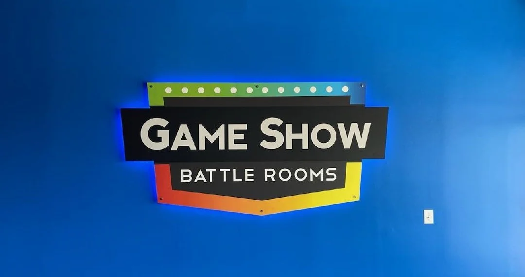 Sign on blue wall for game show battle rooms with colorful border