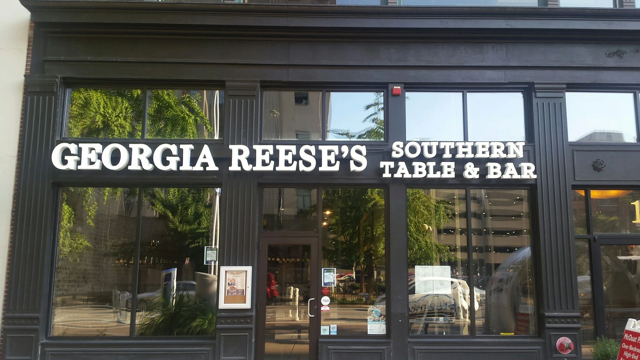 The storefront of Georgia Reese's Southern Table & Bar, with black exterior framing and large glass windows. The store sign displays the name in white letters.