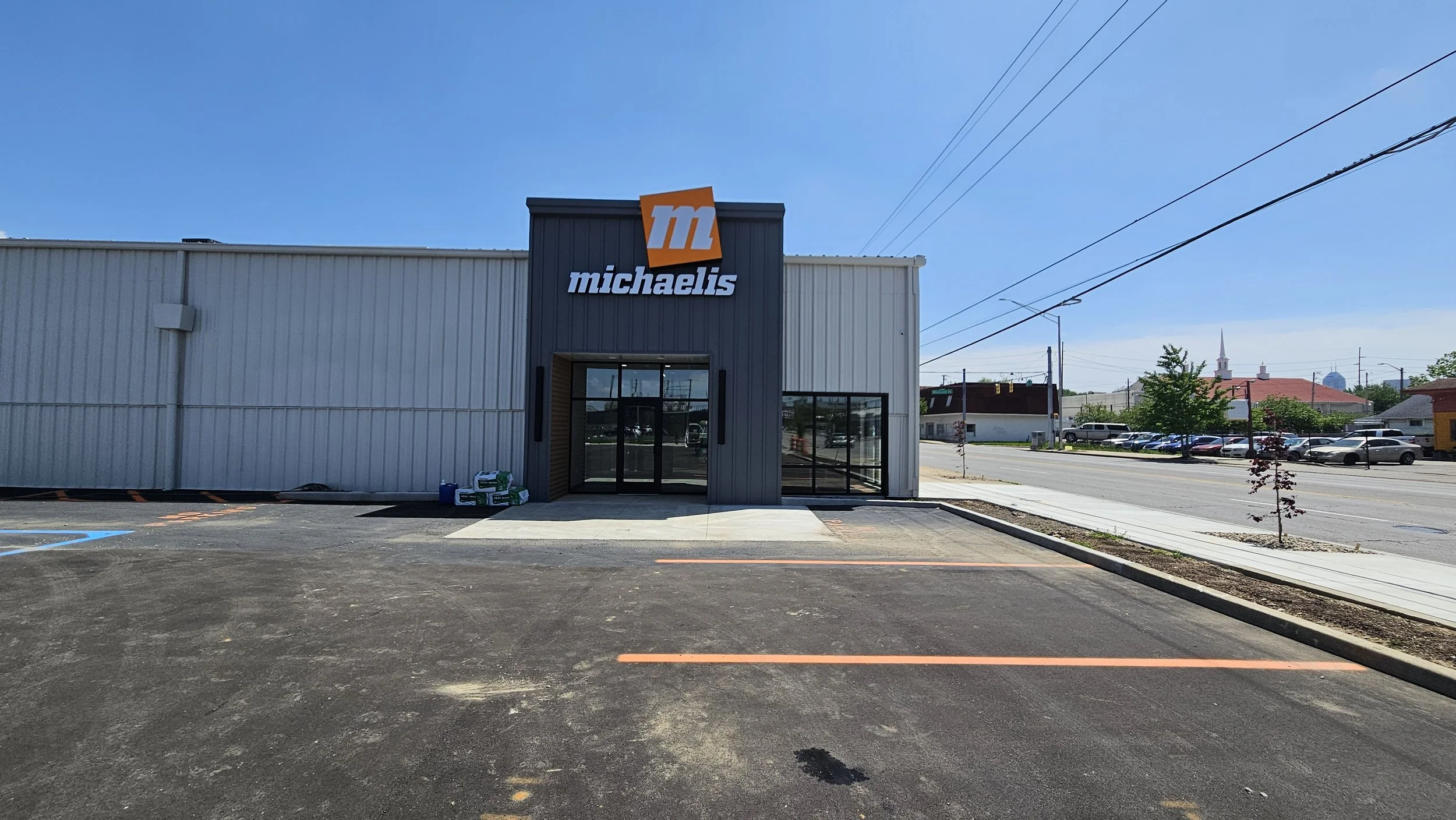 Front view of a Michael's craft store with a blue sky above and parking spaces in the foreground.