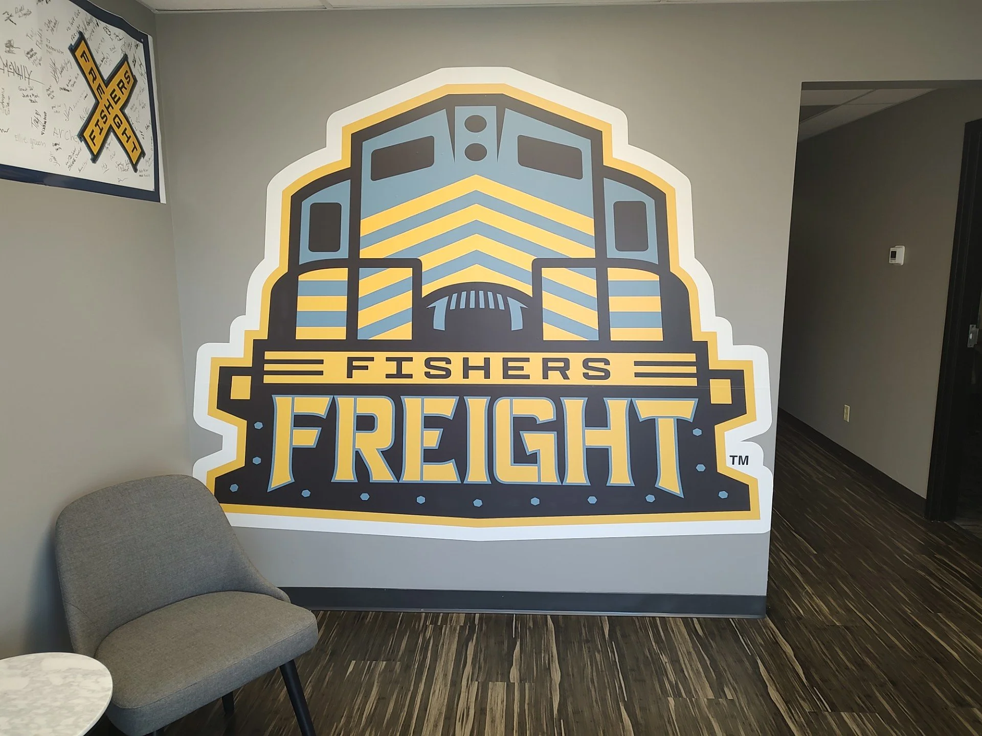 Large logo on a wall for Fishers Freight with stylized truck image and bold text.