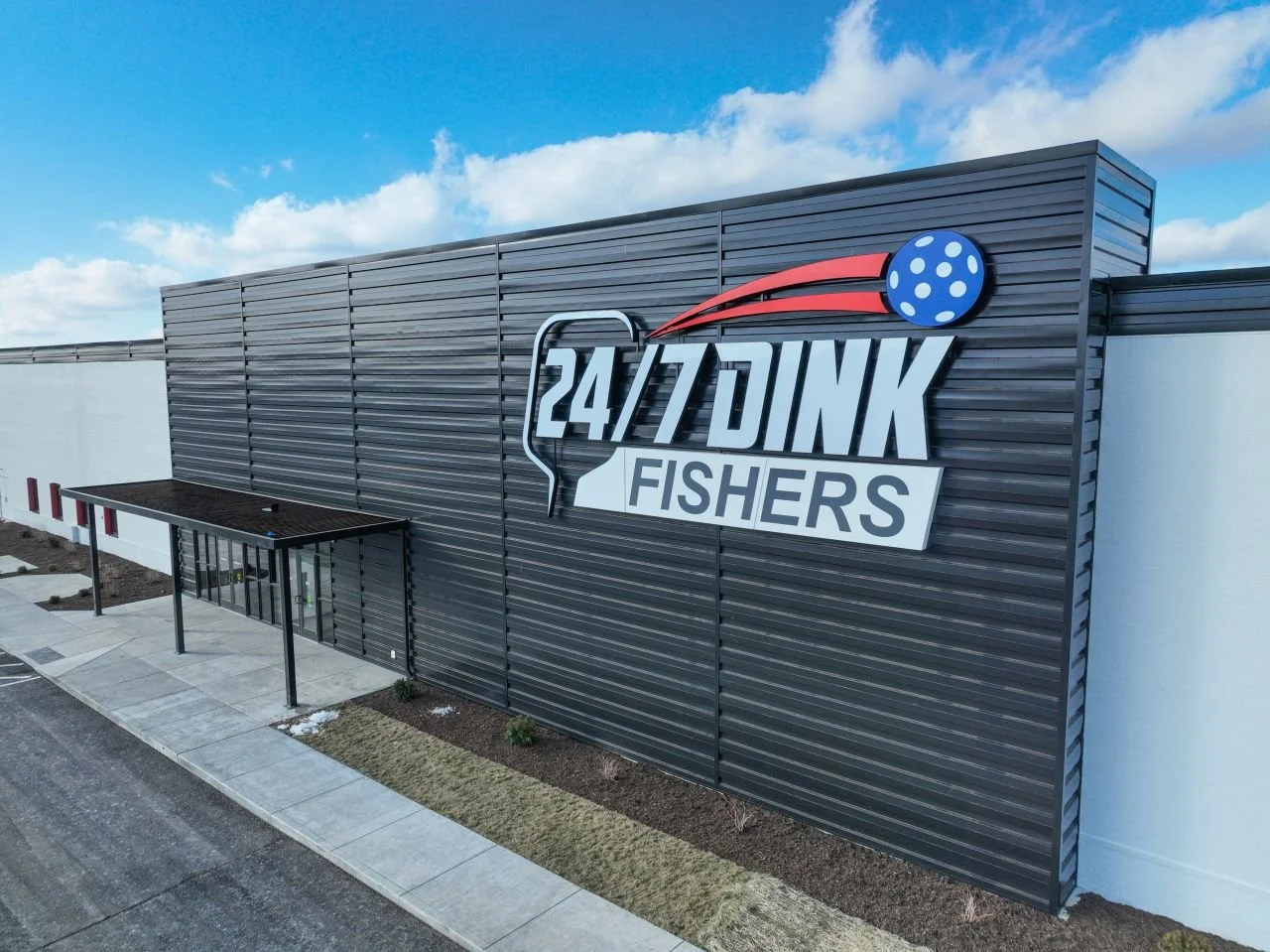 Exterior of a building with a large sign that reads '24/7 DINK FISHERS' with a fishing hook and a stylized fishing bobber above the sign.