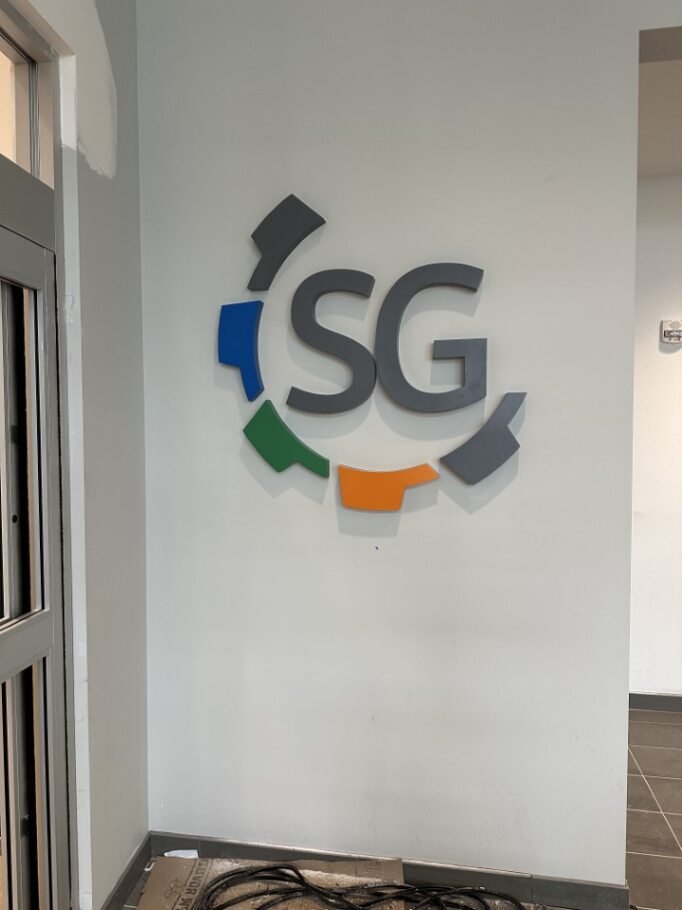 A wall with a logo consisting of the letters 'SG' and a circular design made of different colored segments.