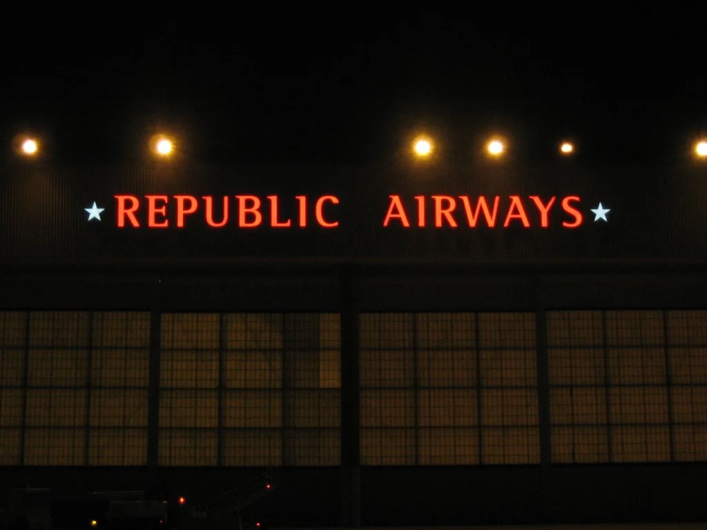 Illuminated sign reading 'REPUBLIC AIRWAYS' with stars on a dark background.